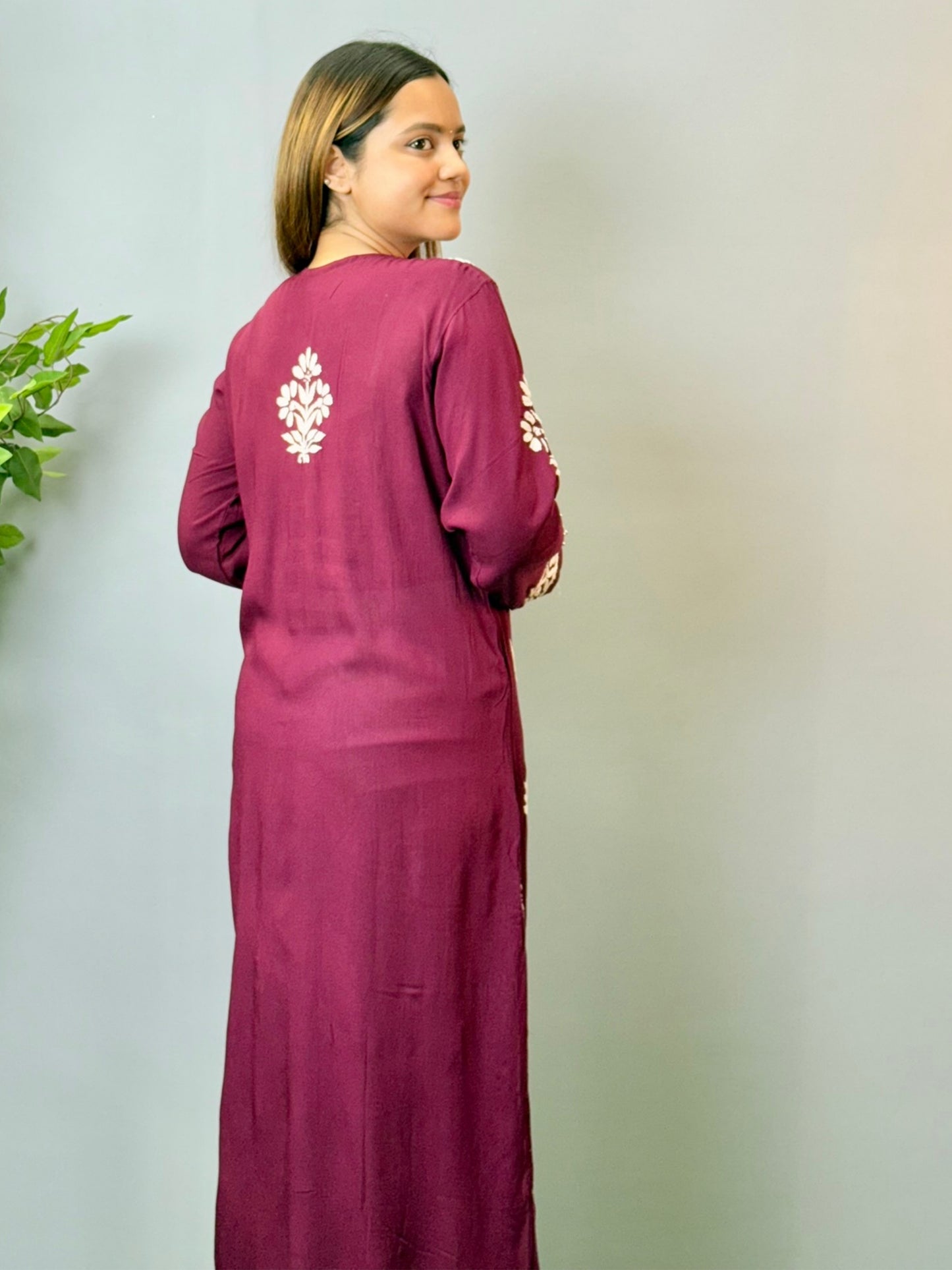 Model wearing a wine maroon Lucknowi chikankari kurta in soft modal fabric with detailed white embroidery work.