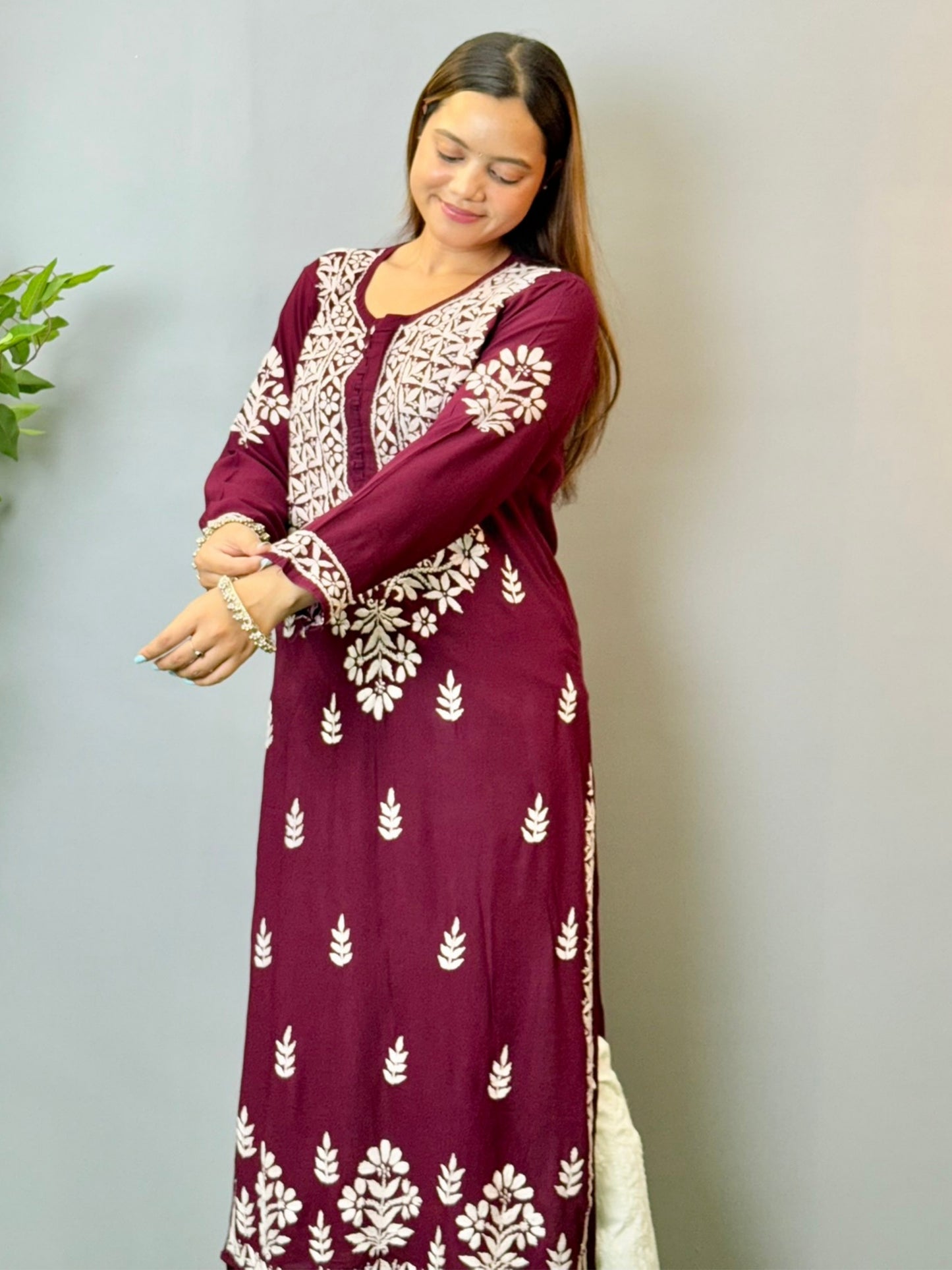 Model wearing a wine maroon Lucknowi chikankari kurta in soft modal fabric with detailed white embroidery work.