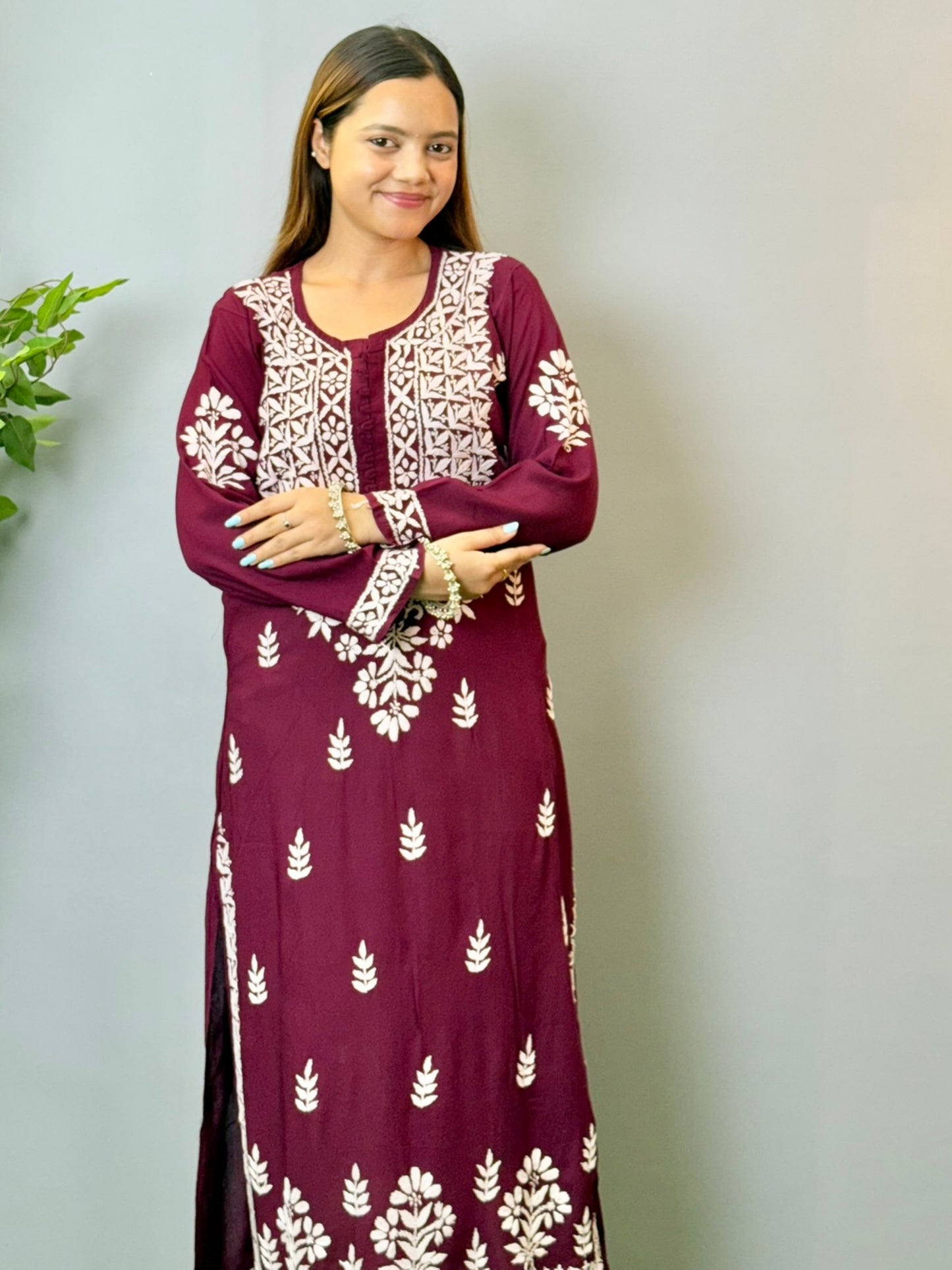 Model wearing a wine maroon Lucknowi chikankari kurta in soft modal fabric with detailed white embroidery work.