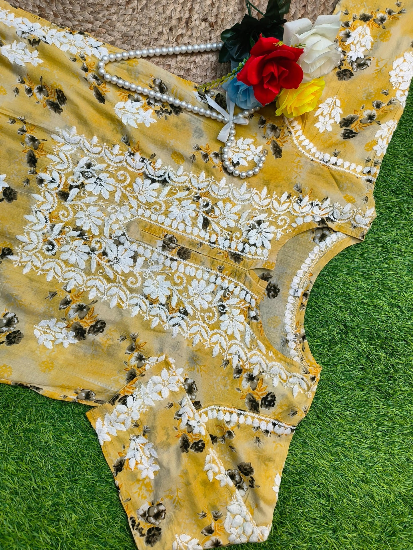 Flat lay of premium mustard yellow floral printed mulmul Lucknowi Chikankari kurta and palazzo set with white embroidery detailing, by R S CHIKANKARI.