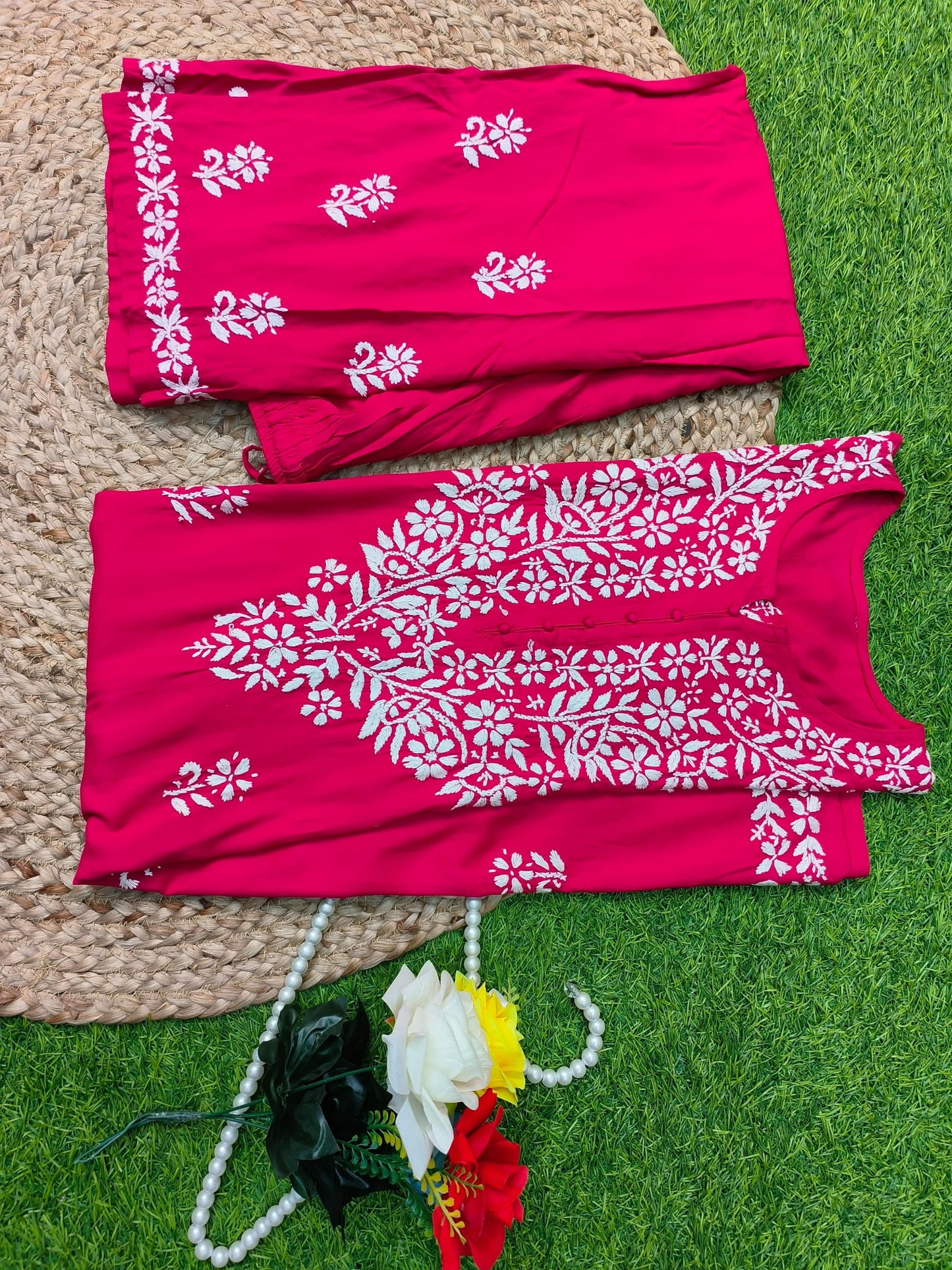Flat lay of premium rani pink rayon Lucknowi Chikankari kurta and palazzo set with white floral embroidery and detailed borders, by R S CHIKANKARI.