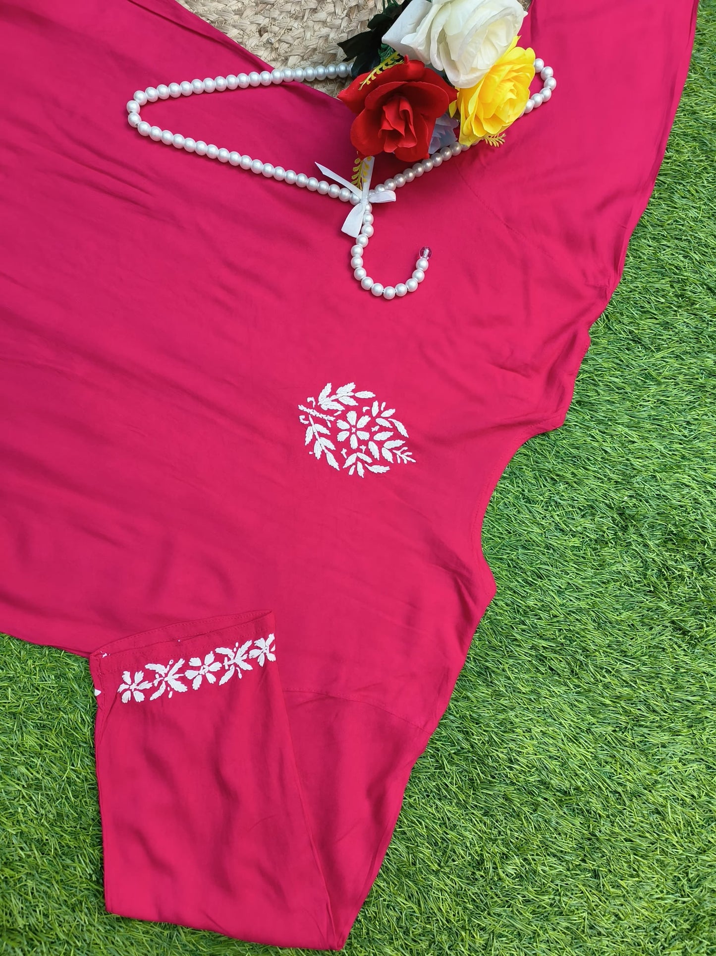 Flat lay of premium rani pink rayon Lucknowi Chikankari kurta and palazzo set with white floral embroidery and detailed borders, by R S CHIKANKARI.