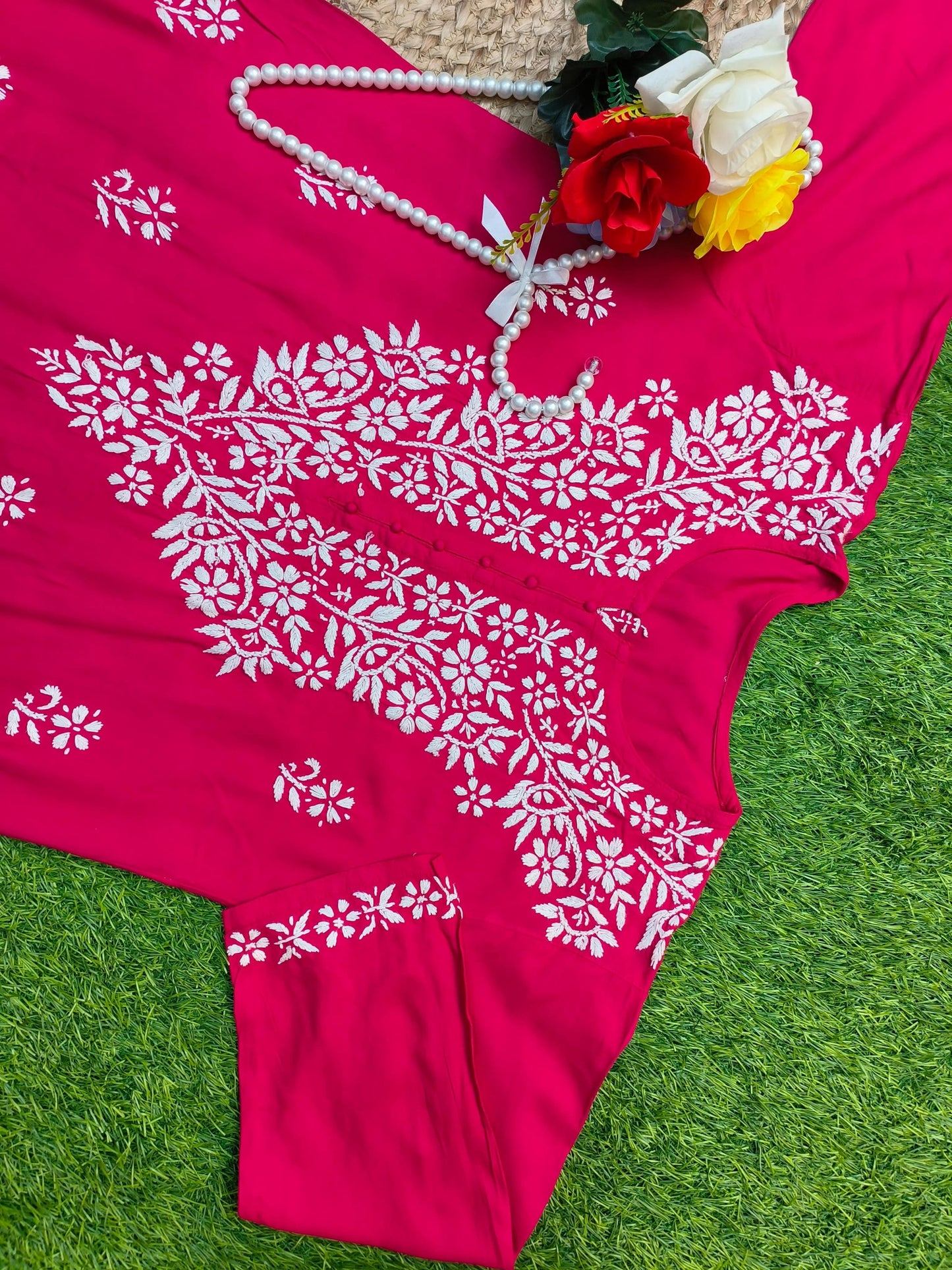 Flat lay of premium rani pink rayon Lucknowi Chikankari kurta and palazzo set with white floral embroidery and detailed borders, by R S CHIKANKARI.