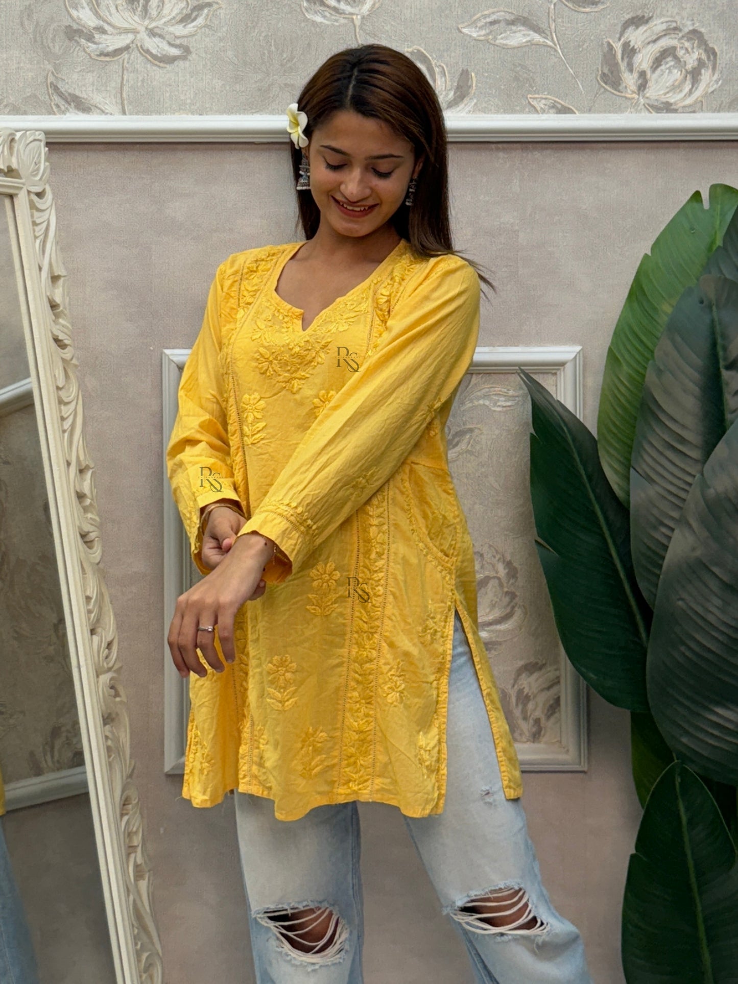 Yellow cotton short chikankari kurta with hand embroidery and side pockets.