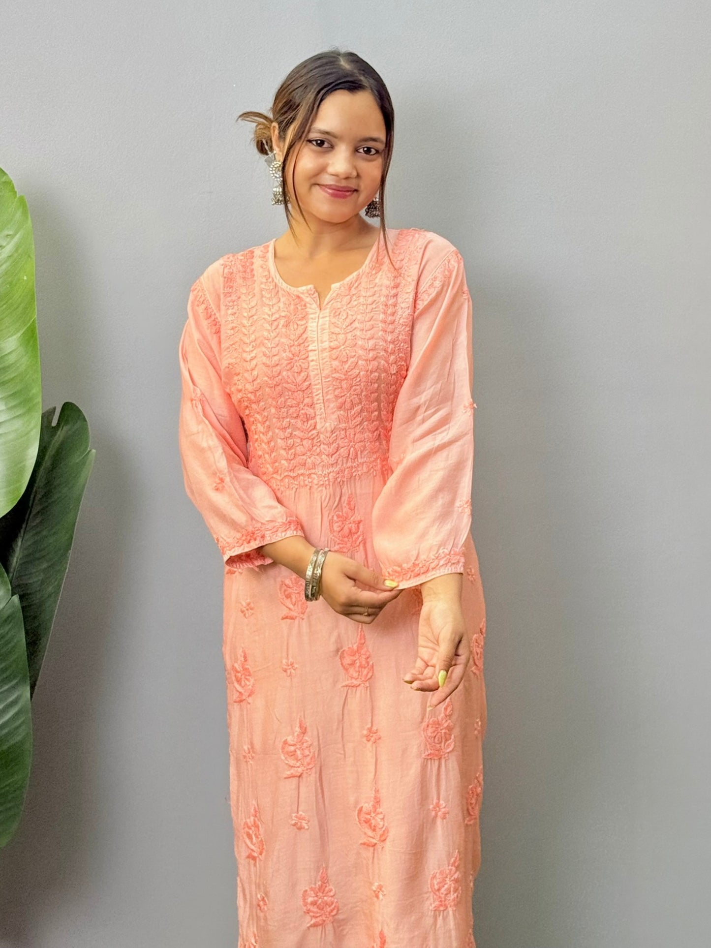 Model wearing peach muslin chikankari kurta with white bottom