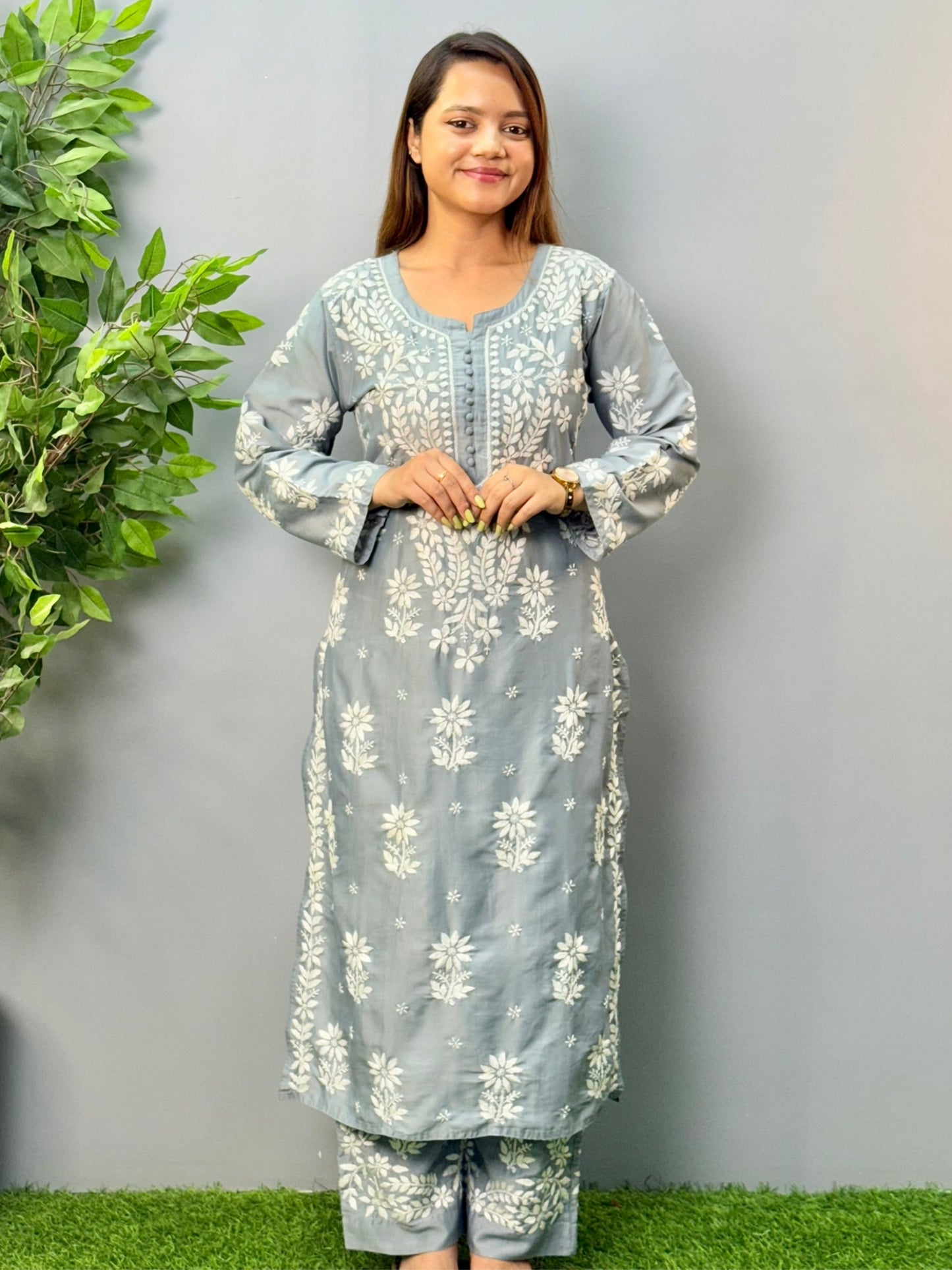 Model wearing a steel grey muslin chikankari kurta and pant set with intricate white embroidery