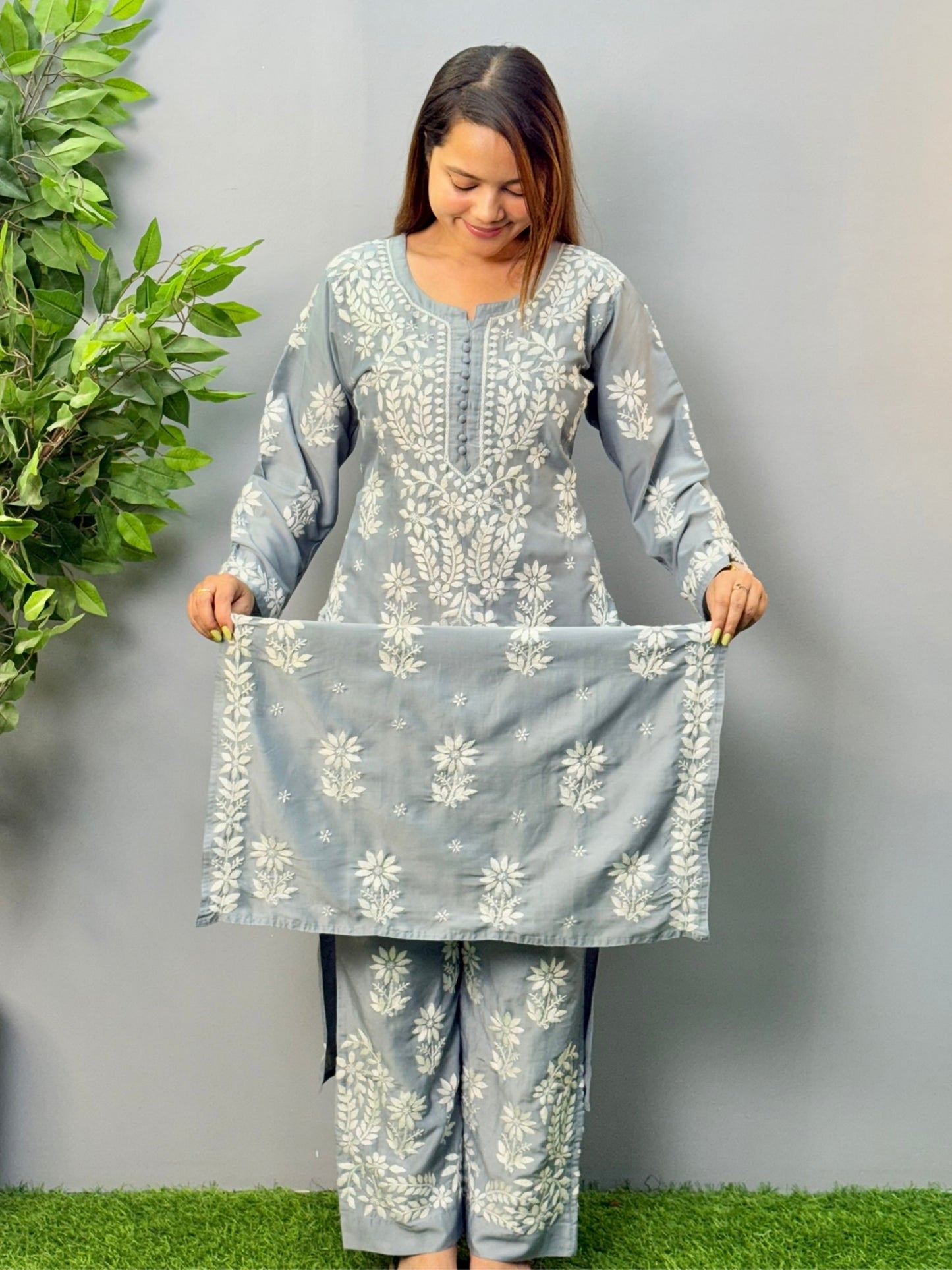 Model wearing a steel grey muslin chikankari kurta and pant set with intricate white embroidery