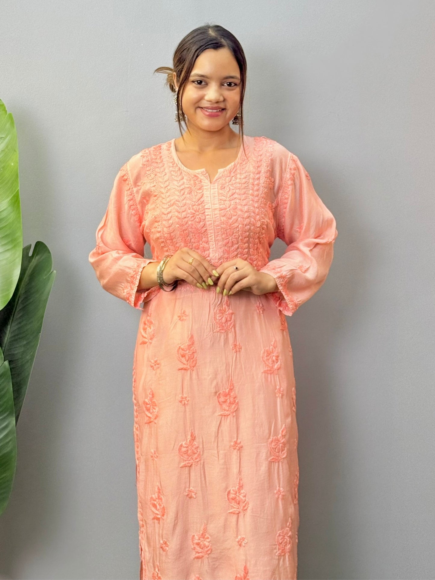 Model wearing peach muslin chikankari kurta with white bottom