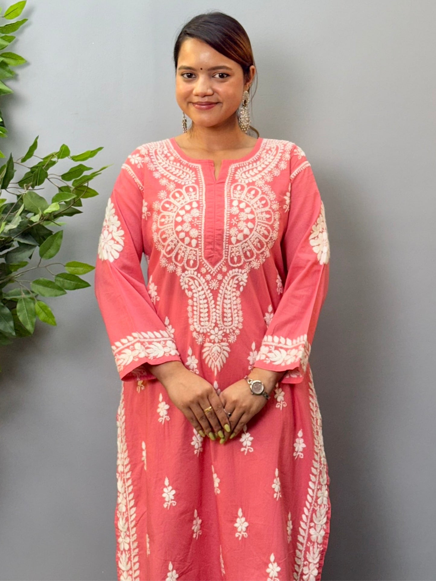 Model wearing a peach cotton chikankari kurta with detailed white hand embroidery