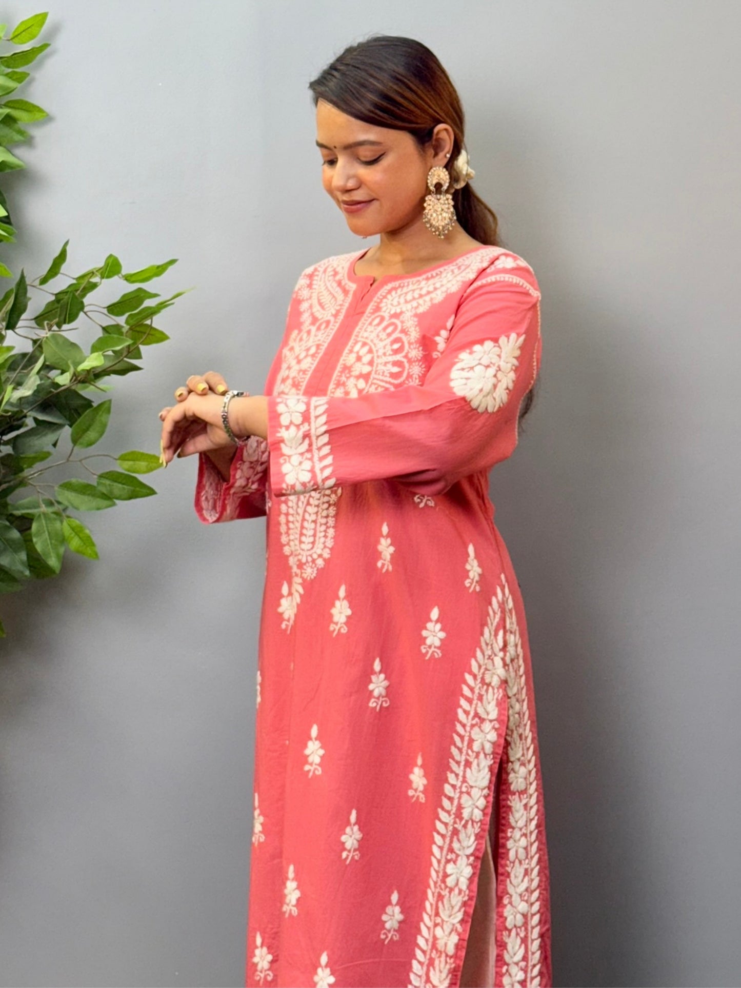 Model wearing a peach cotton chikankari kurta with detailed white hand embroidery