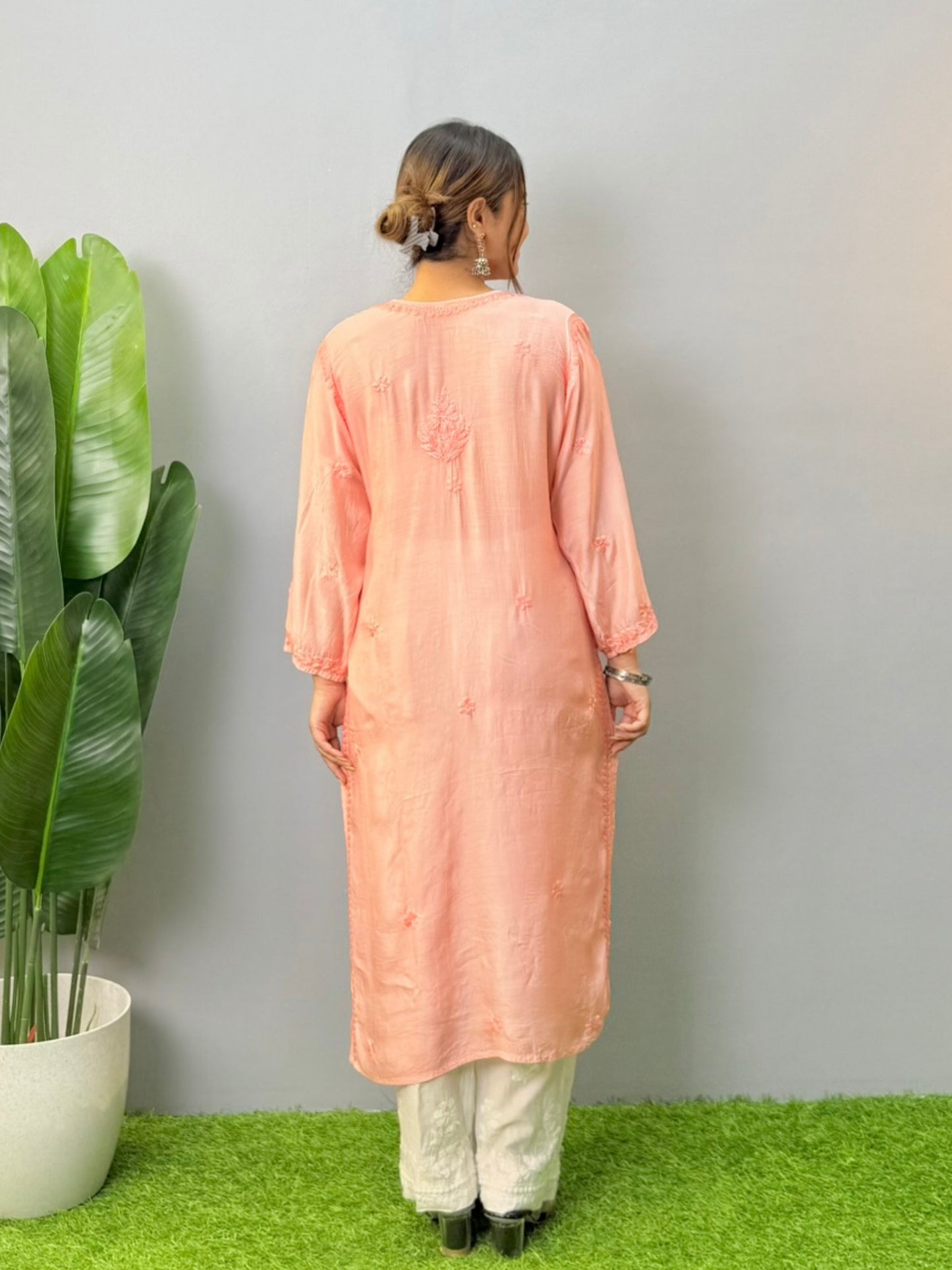 Model wearing peach muslin chikankari kurta with white bottom