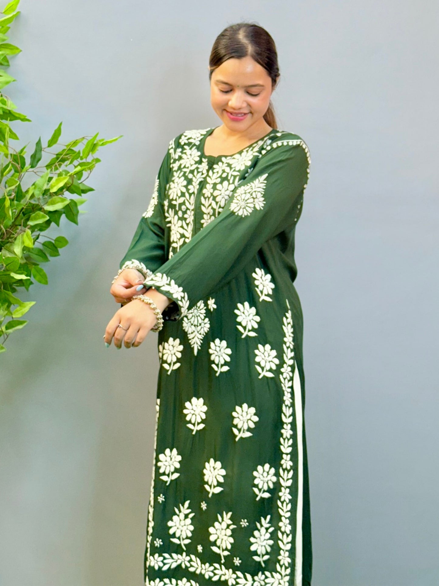 Model wearing a deep forest green modal Lucknowi chikankari kurta with rich white hand embroidery, styled with white palazzos.