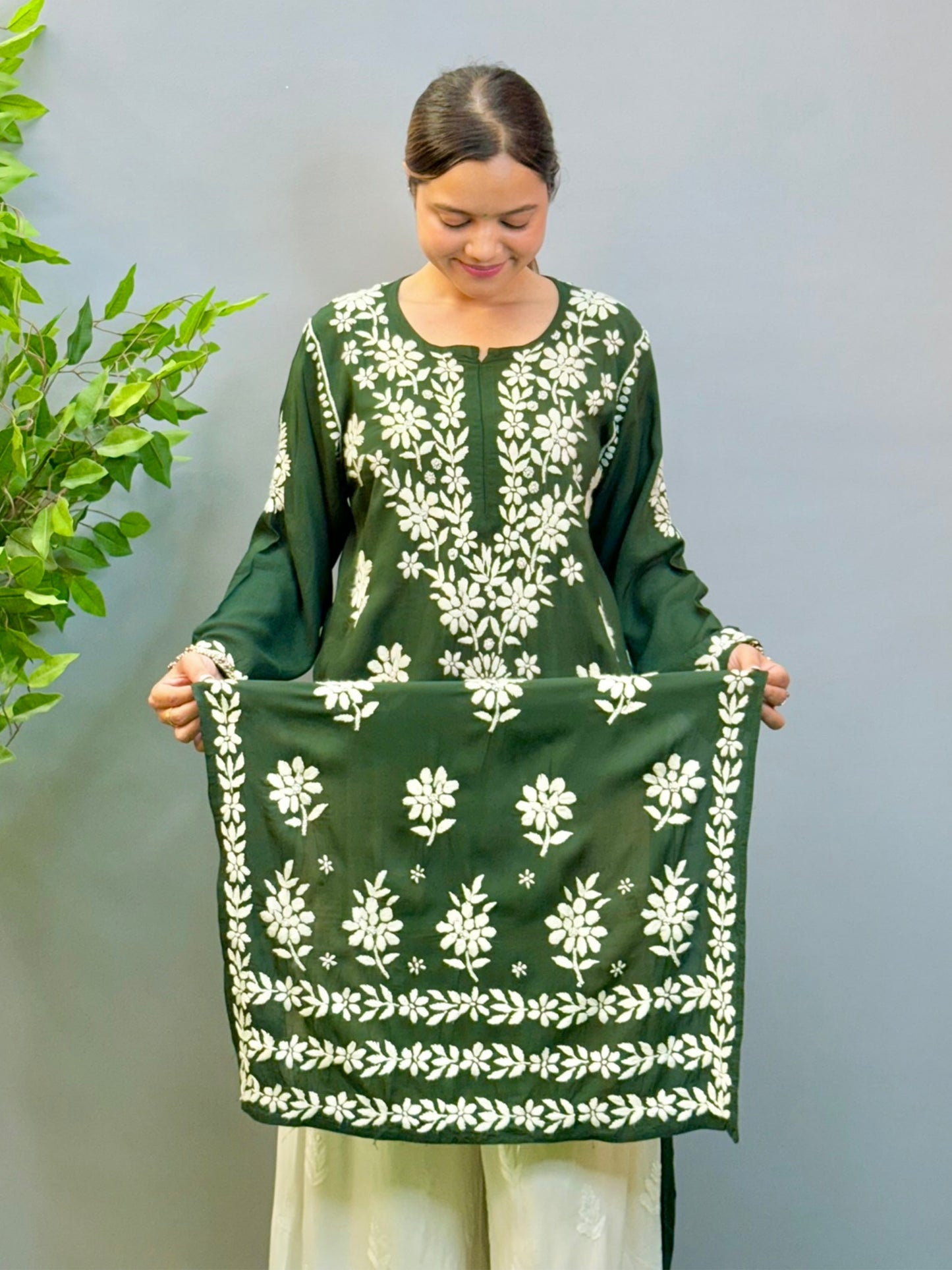 Model wearing a deep forest green modal Lucknowi chikankari kurta with rich white hand embroidery, styled with white palazzos.
