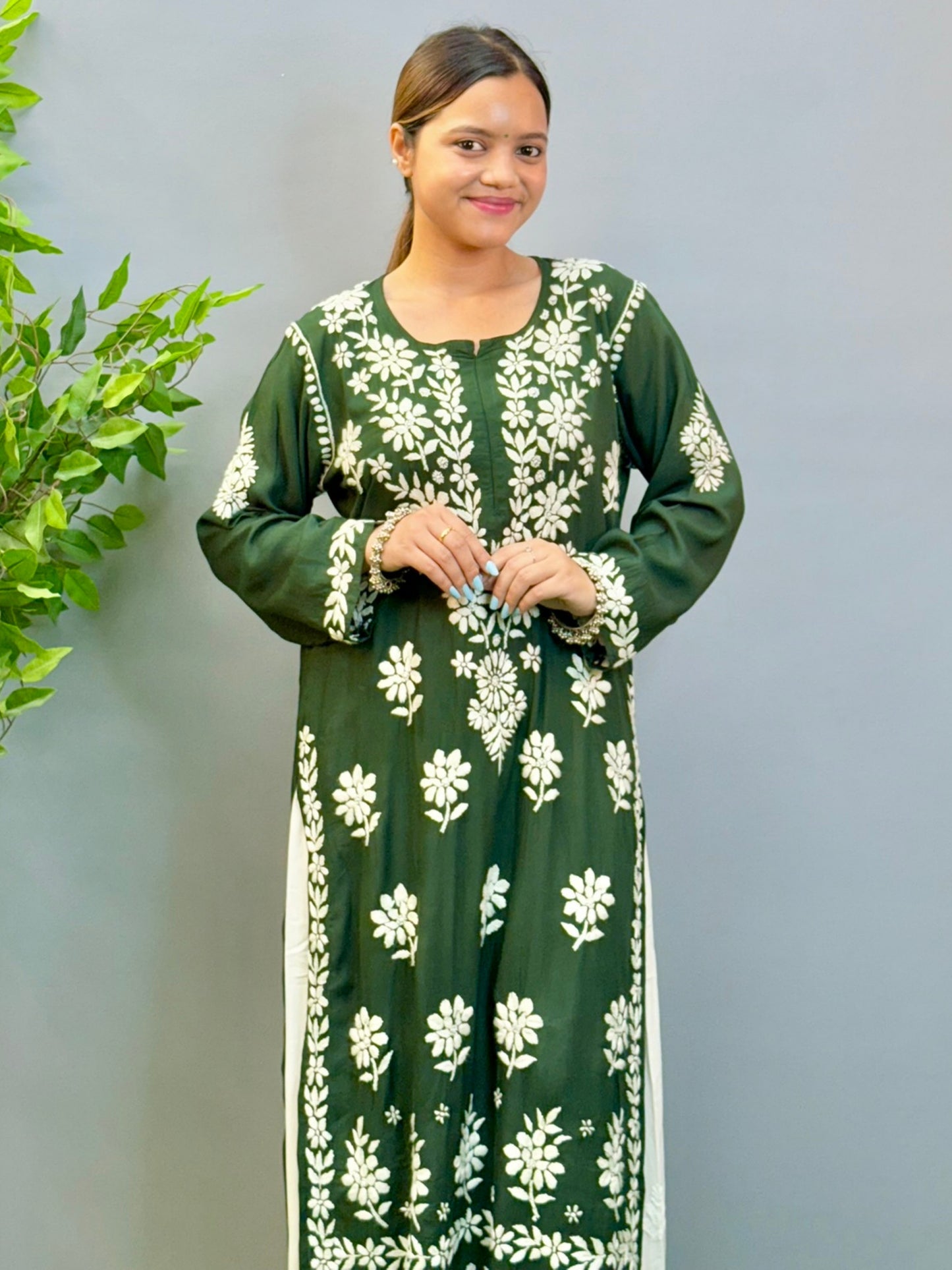 Model wearing a deep forest green modal Lucknowi chikankari kurta with rich white hand embroidery, styled with white palazzos.