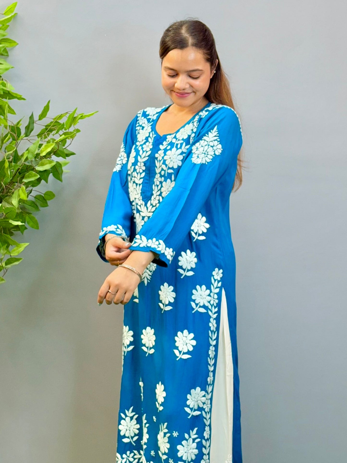 Woman wearing teal blue Chikankari kurta with white embroidery on modal fabric.