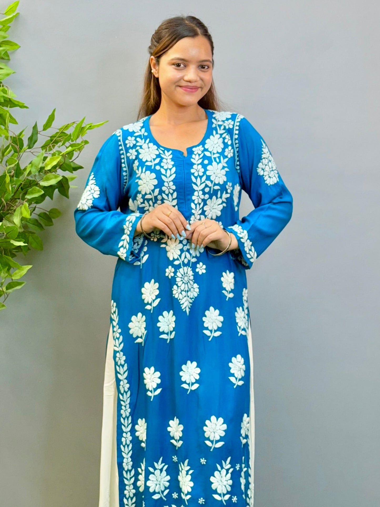 Woman wearing teal blue Chikankari kurta with white embroidery on modal fabric.
