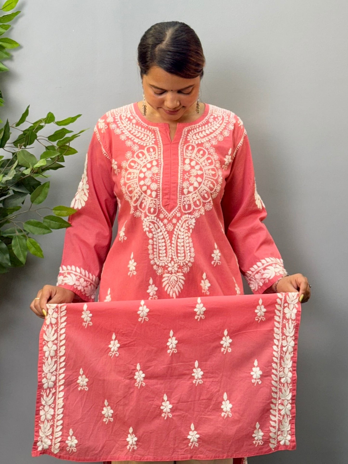 Model wearing a peach cotton chikankari kurta with detailed white hand embroidery
