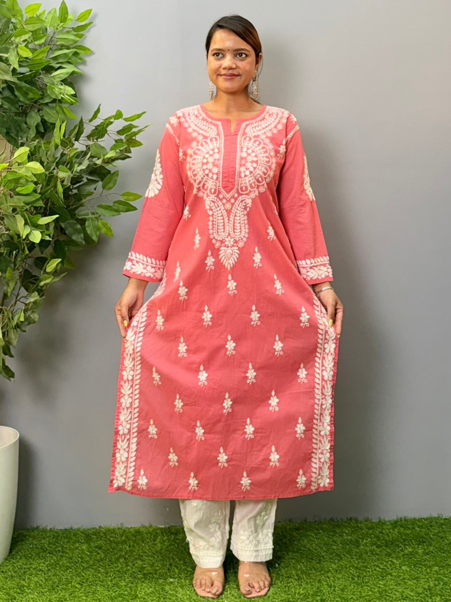 Model wearing a peach cotton chikankari kurta with detailed white hand embroidery