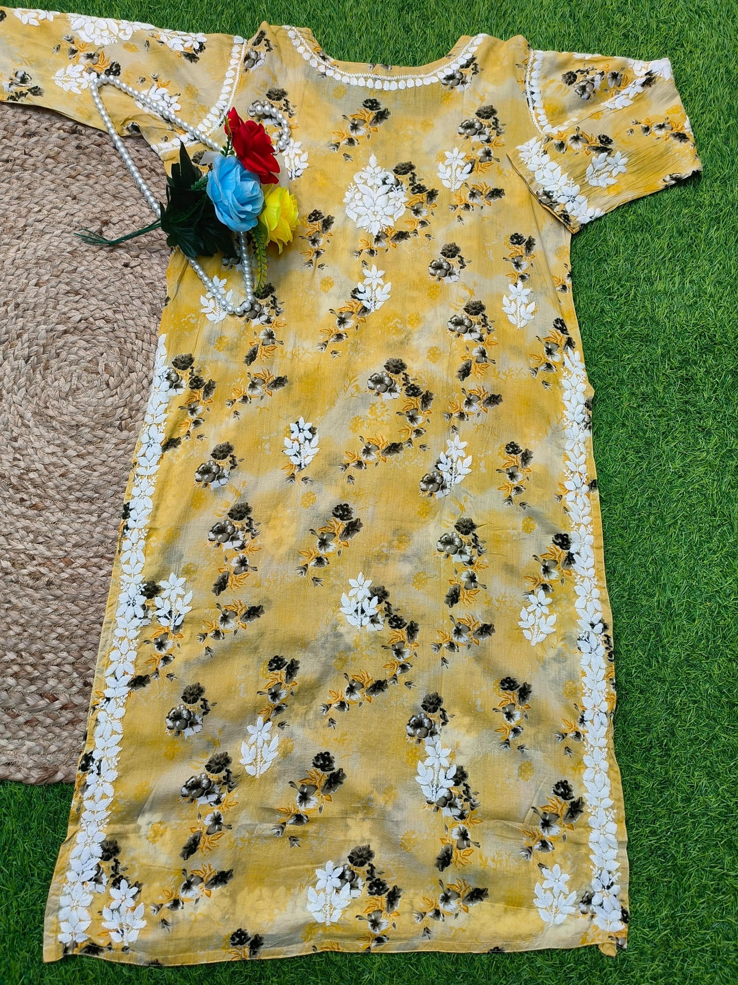 Flat lay of premium mustard yellow floral printed mulmul Lucknowi Chikankari kurta and palazzo set with white embroidery detailing, by R S CHIKANKARI.