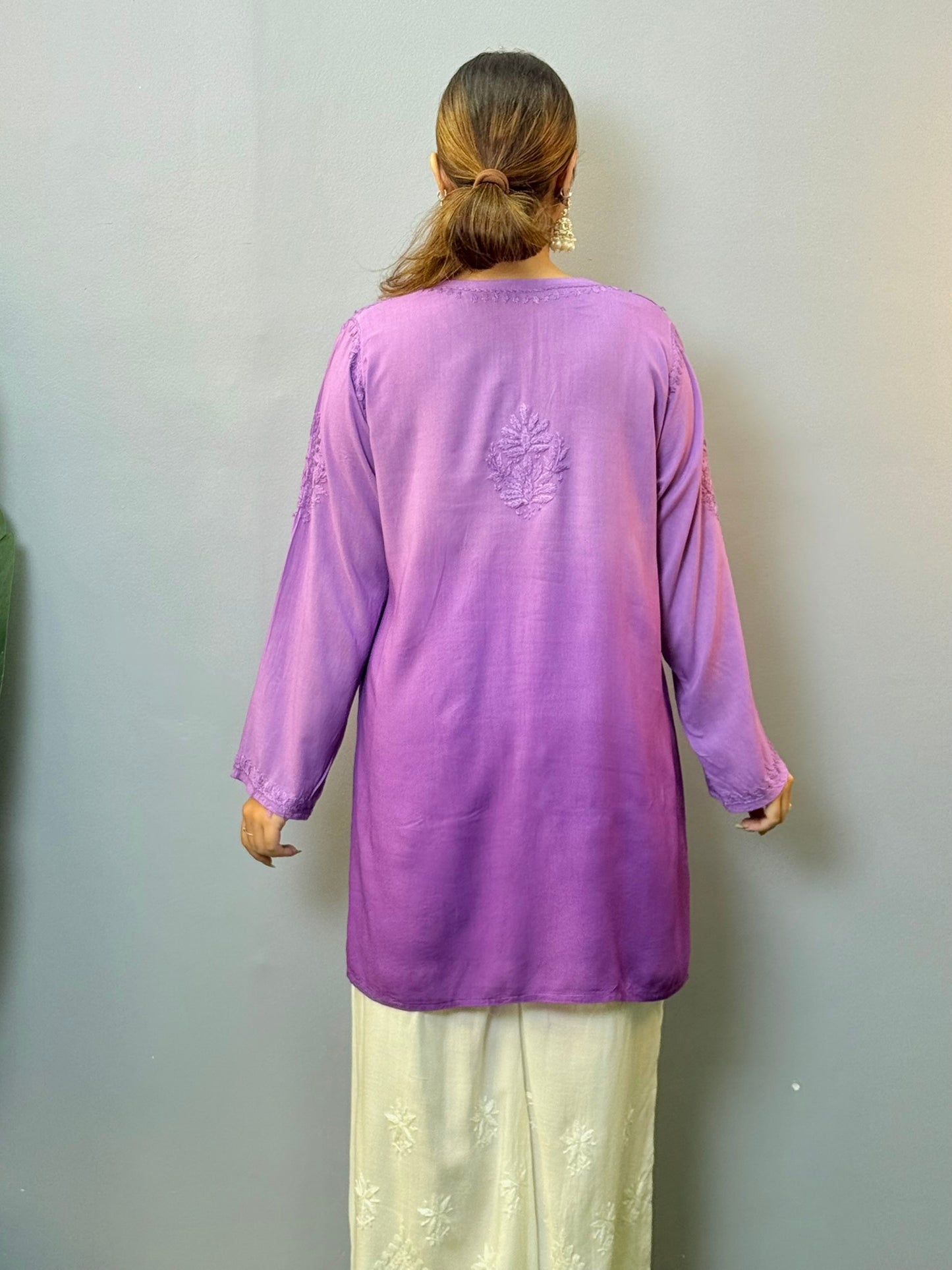 Woman wearing purple short modal chikankari kurta with matching hand embroidery, paired with white palazzo