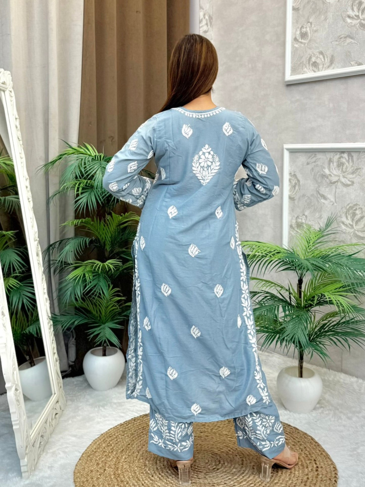 Model wearing a grey muslin Lucknowi chikankari kurta and pant set with white floral embroidery, styled for an elegant ethnic look.