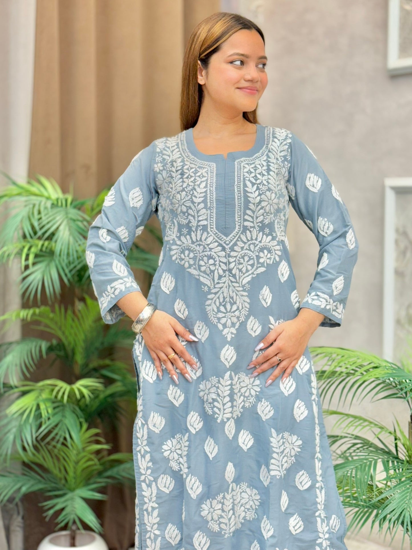 Model wearing a grey muslin Lucknowi chikankari kurta and pant set with white floral embroidery, styled for an elegant ethnic look.