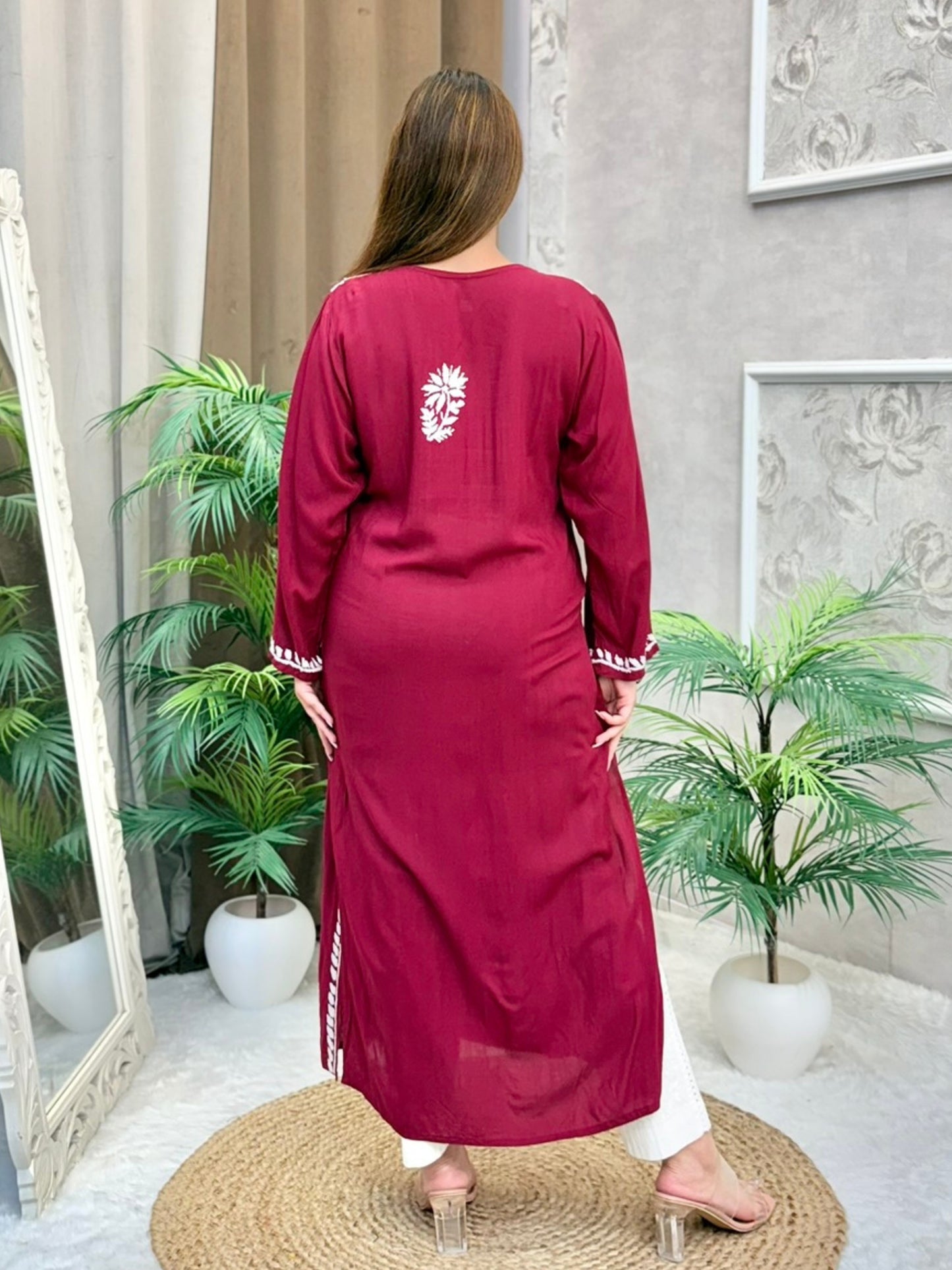 Model wearing a maroon Lucknowi chikankari angrakha-style kurta with white floral embroidery, in premium modal fabric.