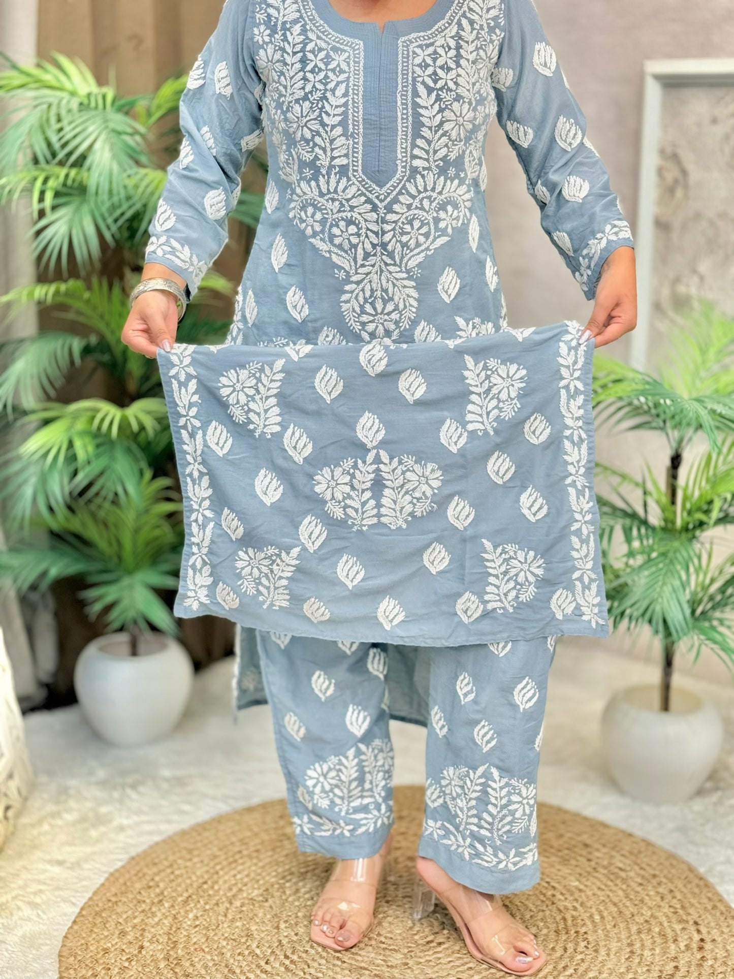 Model wearing a grey muslin Lucknowi chikankari kurta and pant set with white floral embroidery, styled for an elegant ethnic look.