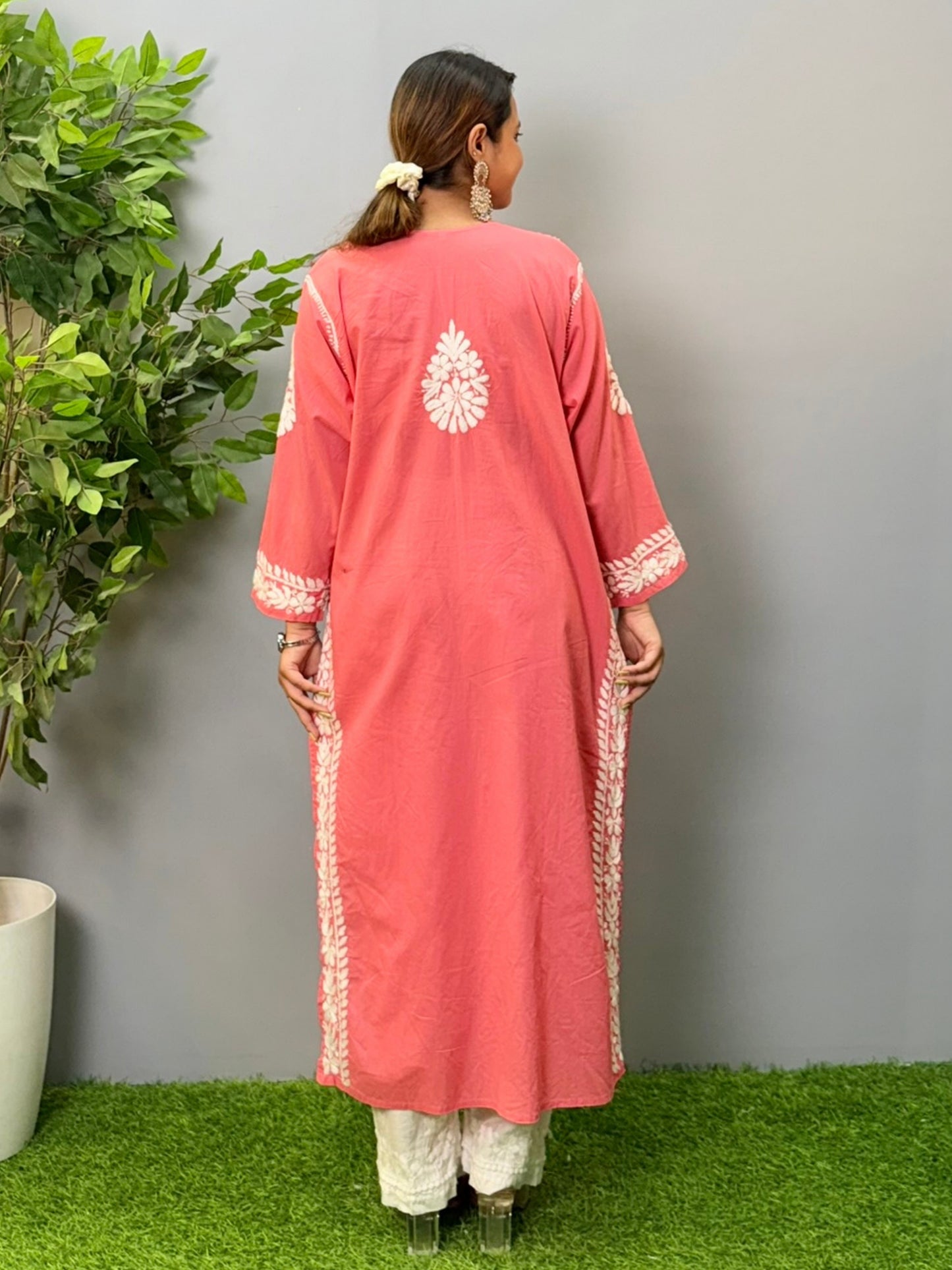 Model wearing a peach cotton chikankari kurta with detailed white hand embroidery