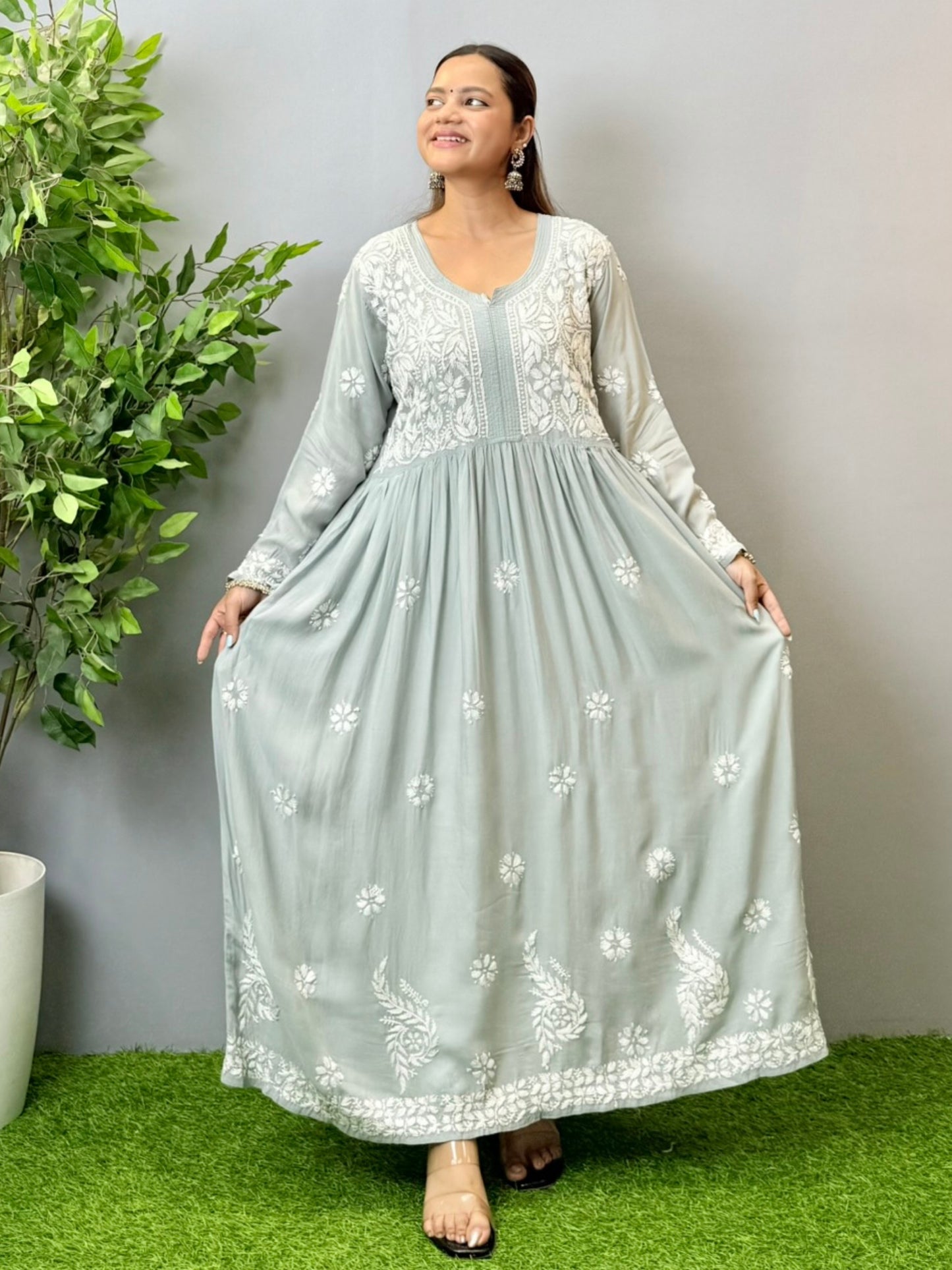 Model wearing a dusty grey Lucknowi chikankari long frock in modal fabric with intricate white hand embroidery and soft flared styling.