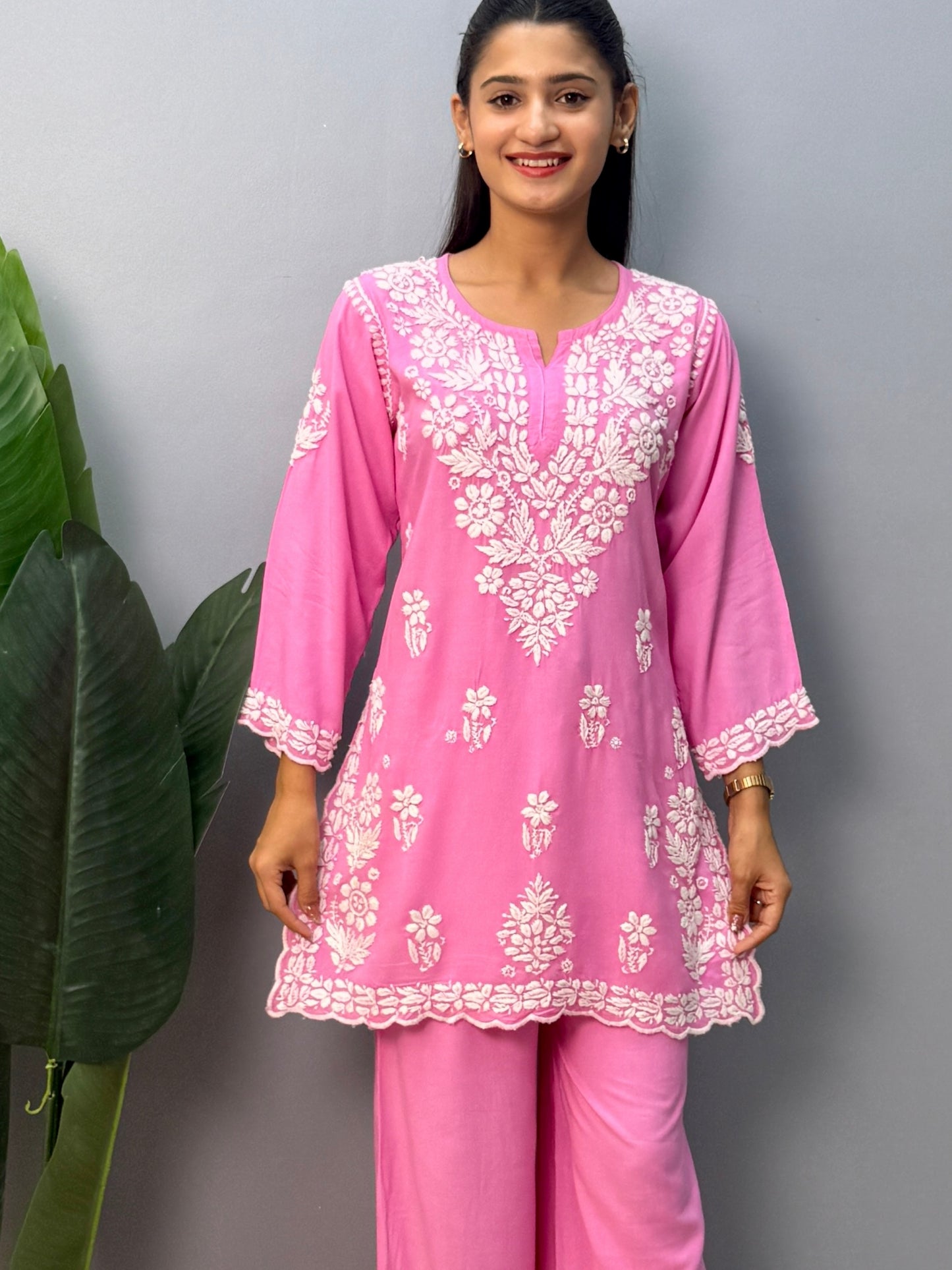 Pink rayon short kurta with palazzo pant featuring white hand-embroidered Lucknow Chikankari design.