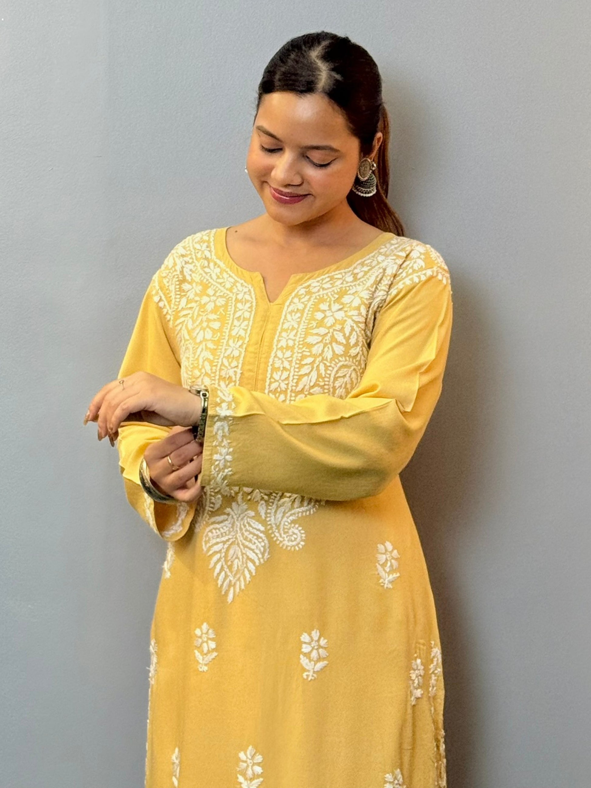 Woman wearing mustard yellow rayon kurta with white hand-embroidered Lucknowi Chikankari
