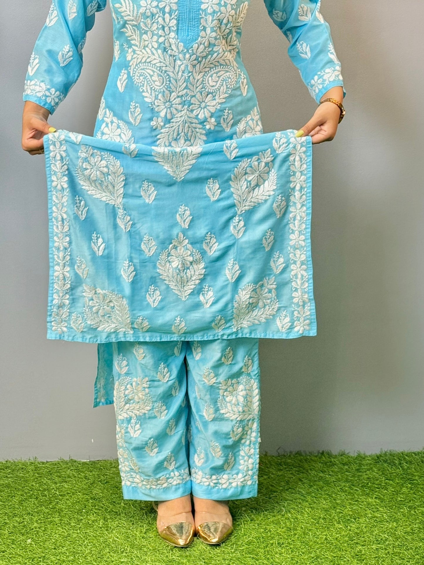Woman wearing sky blue muslin Chikankari kurta and pant set with intricate white embroidery