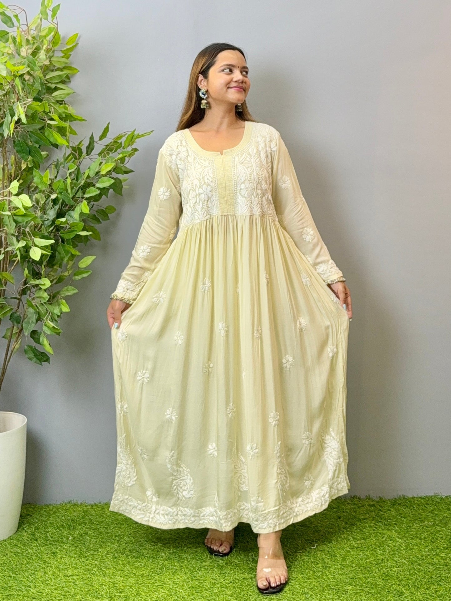 Model wearing an ivory cream Lucknowi chikankari long frock in modal fabric with white hand embroidery and soft flowy drape.