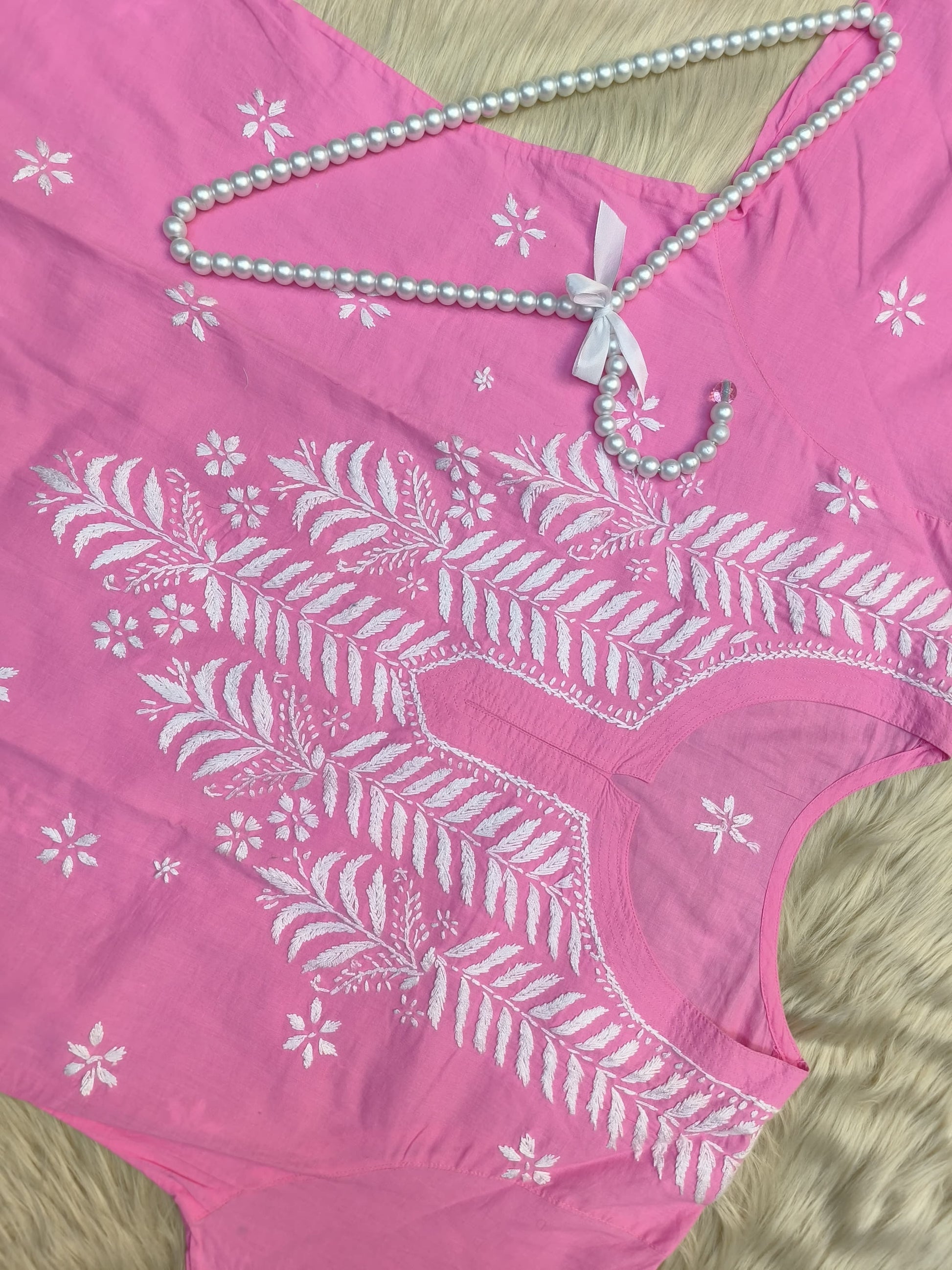 Flat lay of pink cotton chikankari kurta with white hand embroidery