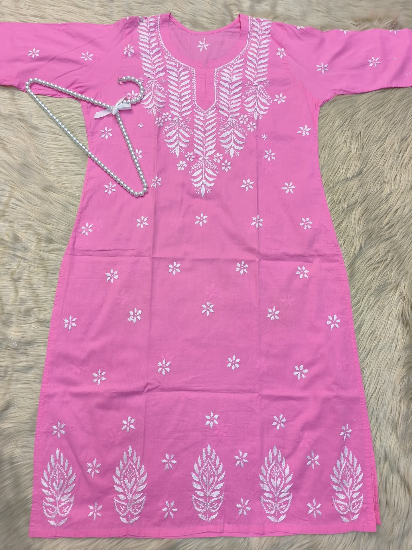 Flat lay of pink cotton chikankari kurta with white hand embroidery