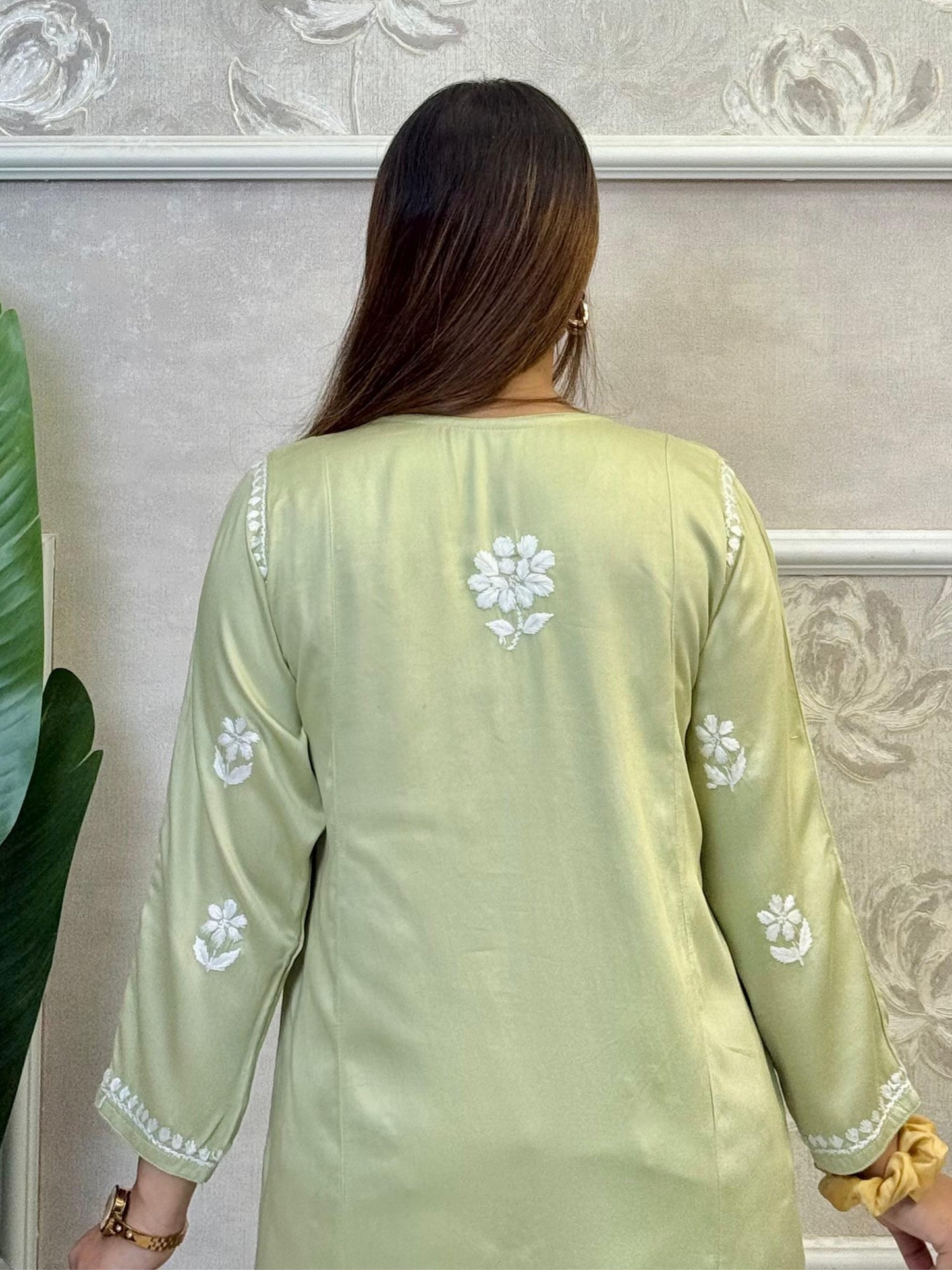 Light green satin short kurta with white Chikankari embroidery, worn with ripped jeans