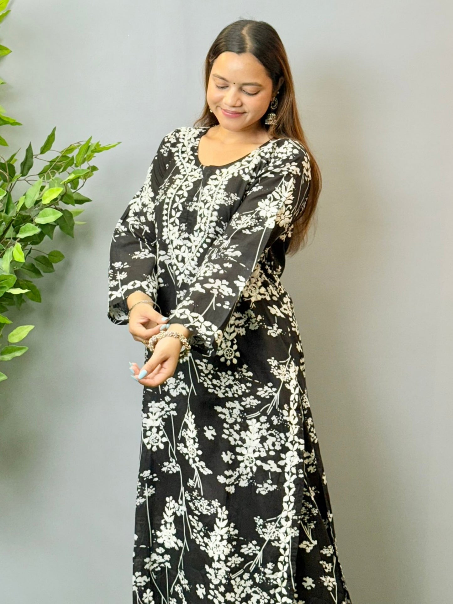 Model wearing a black floral printed Lucknowi chikankari kurta with matching palazzo in mulmul fabric and white embroidery.