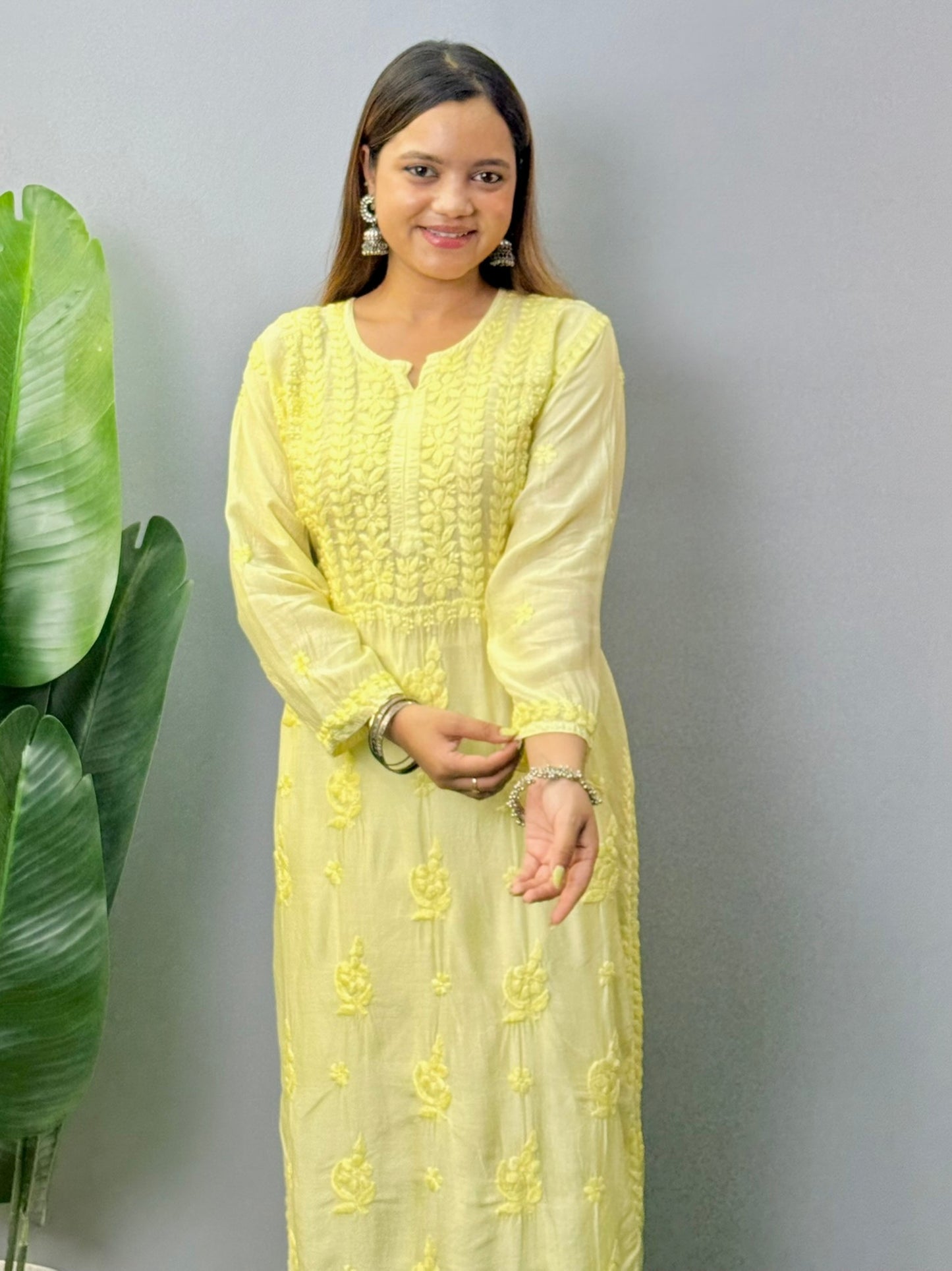 Model wearing lemon yellow muslin chikankari kurta with white pants
