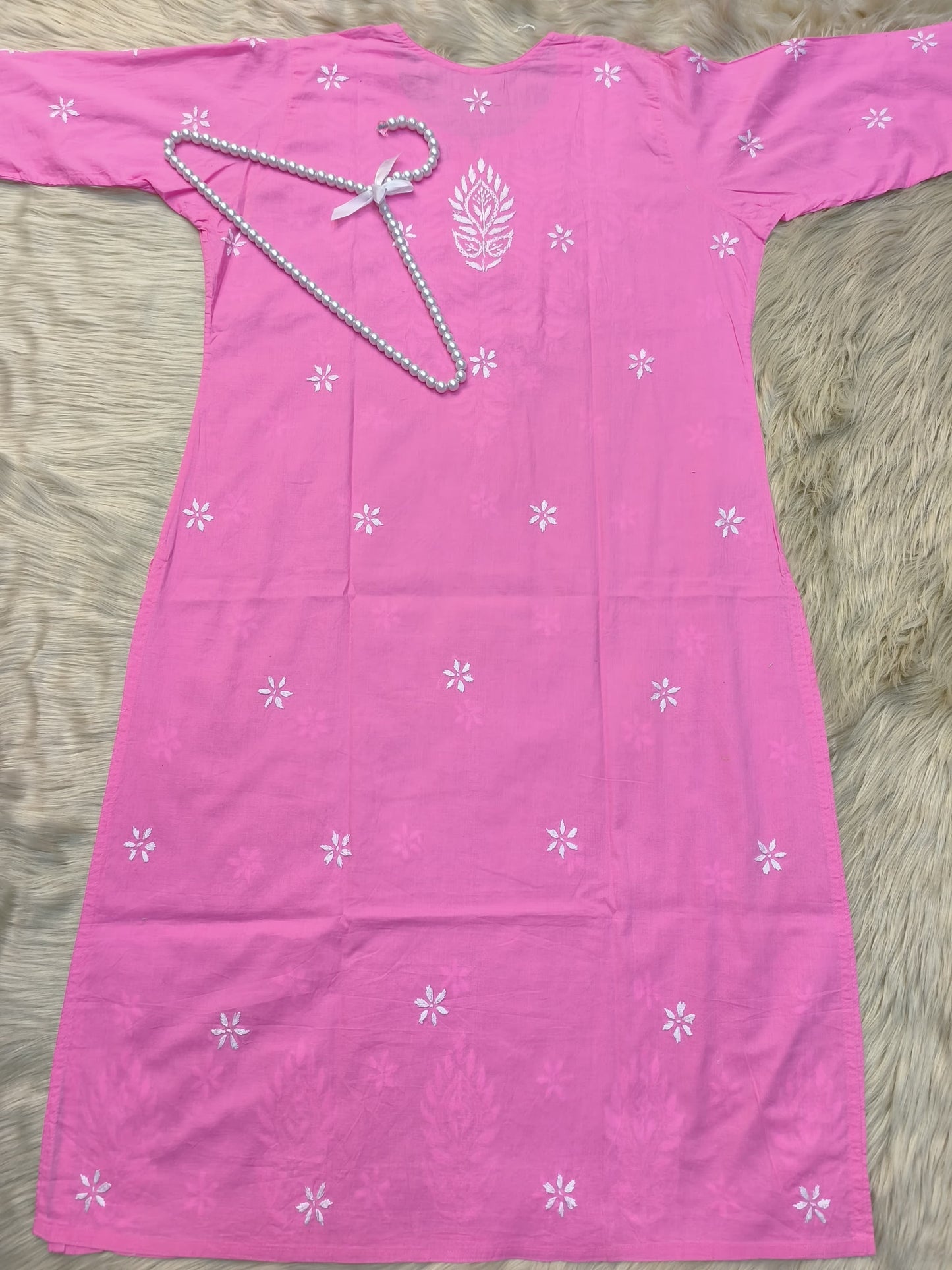Flat lay of pink cotton chikankari kurta with white hand embroidery