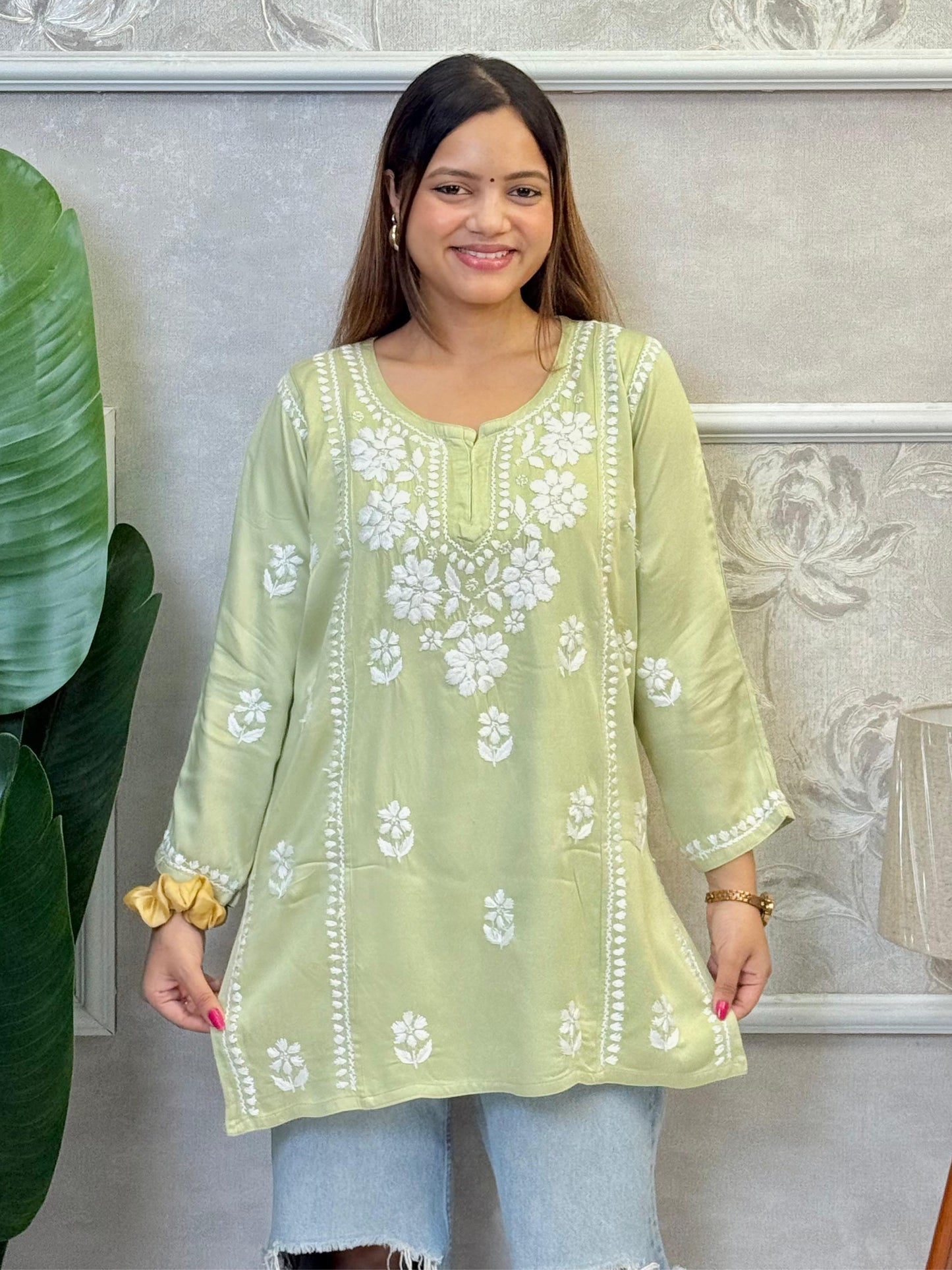 Light green satin short kurta with white Chikankari embroidery, worn with ripped jeans