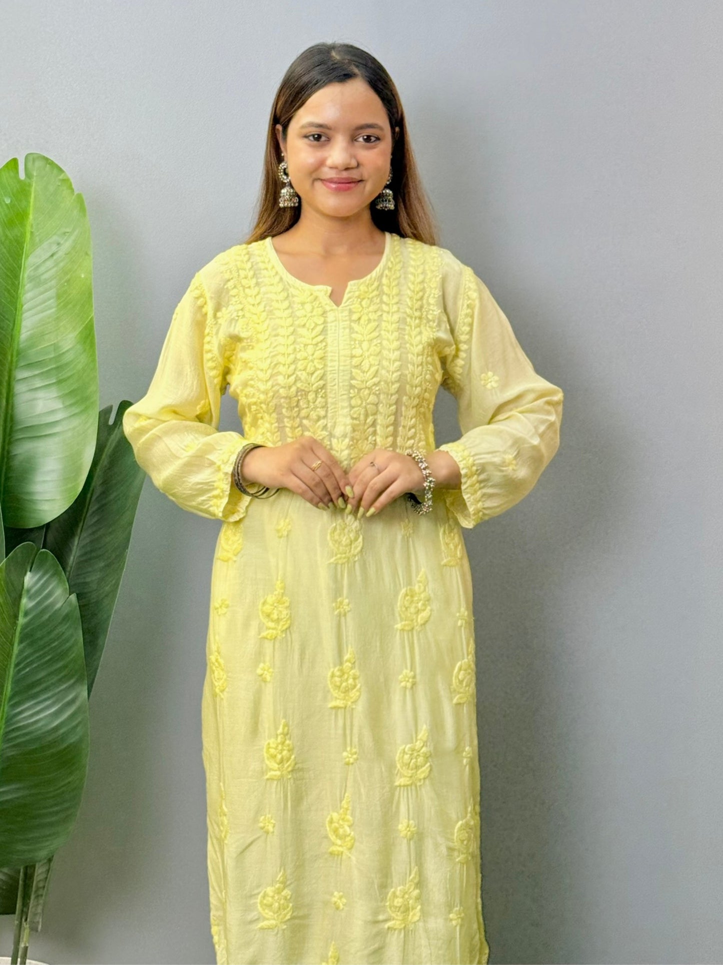 Model wearing lemon yellow muslin chikankari kurta with white pants