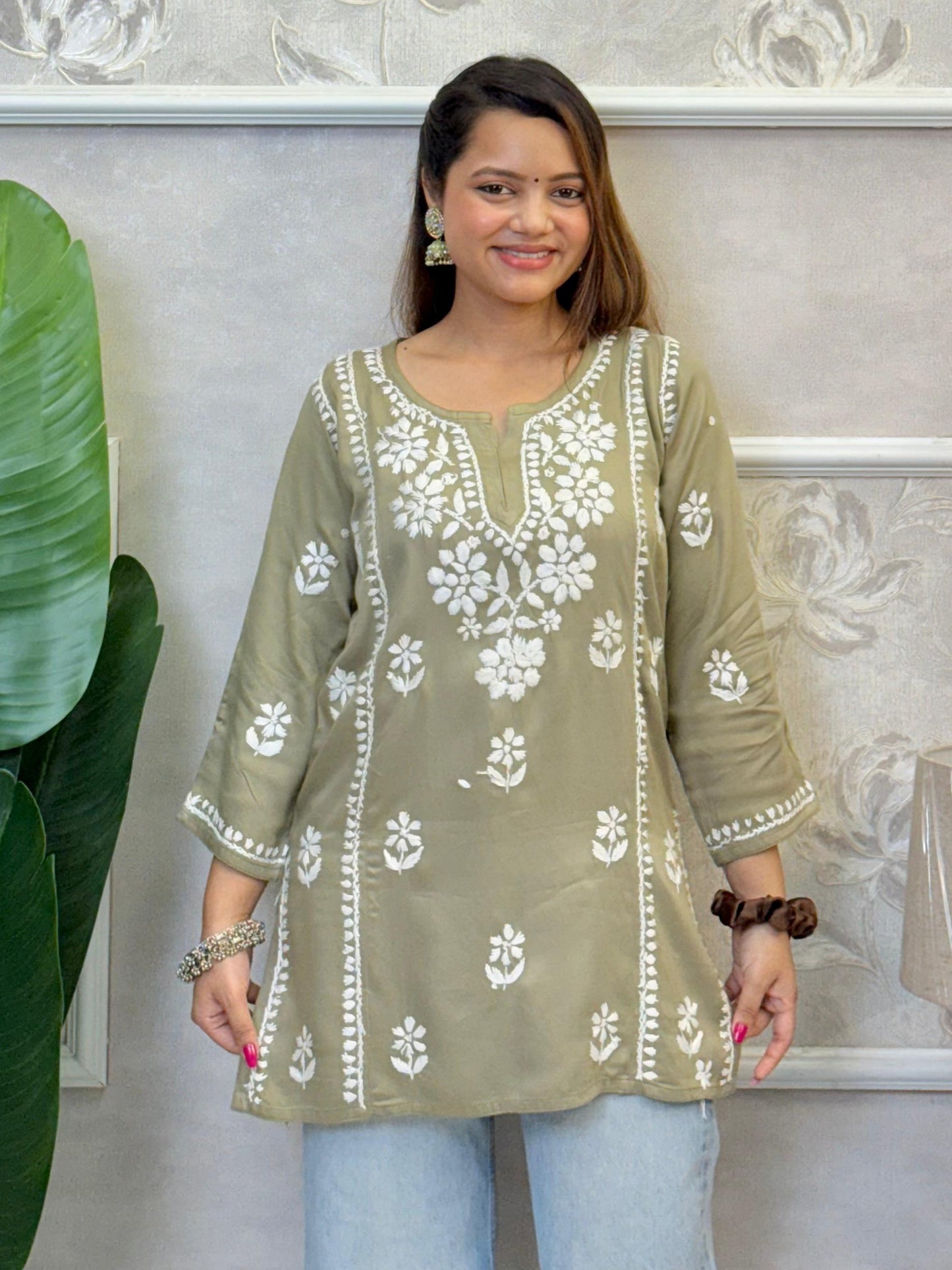 Olive green satin Lucknow Chikankari short kurta with white hand embroidery, full sleeves, and elegant floral patterns.