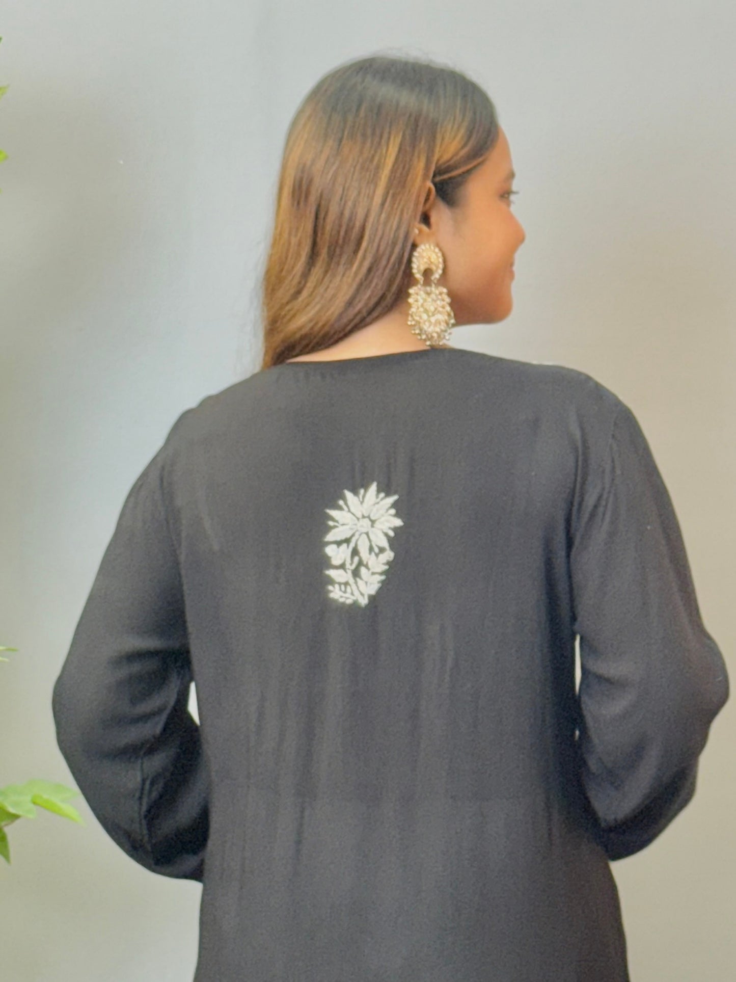 Model wearing a black modal angrakha kurta with elegant white chikankari embroidery and straight silhouette.