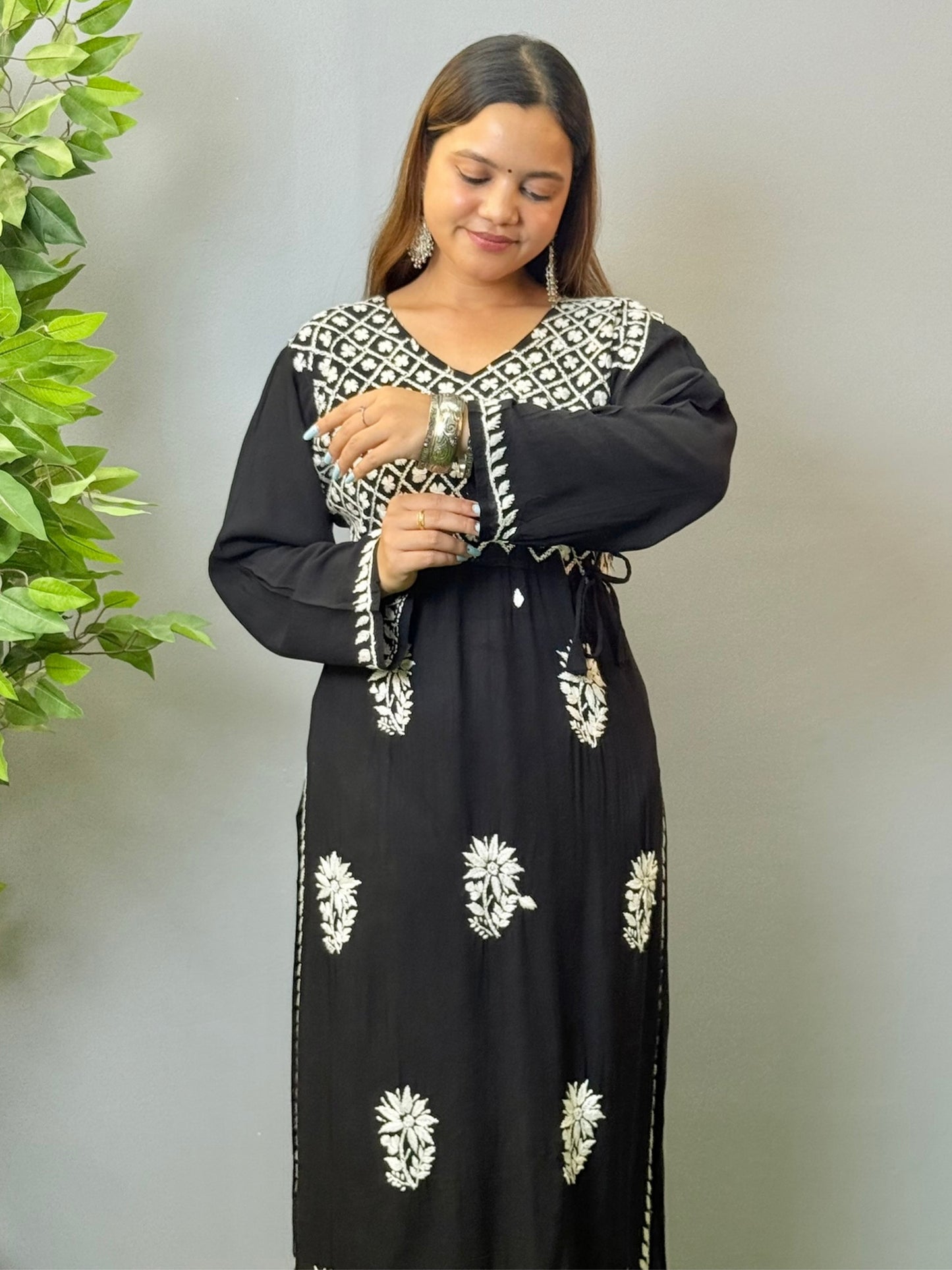 Model wearing a black modal angrakha kurta with elegant white chikankari embroidery and straight silhouette.