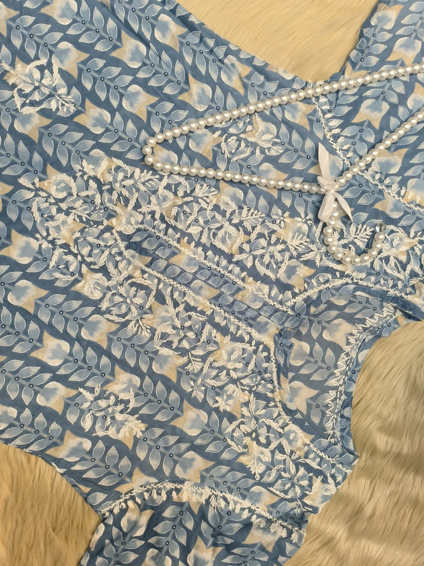 Flat lay of powder blue printed mulmul chikankari kurta with hand embroidery
