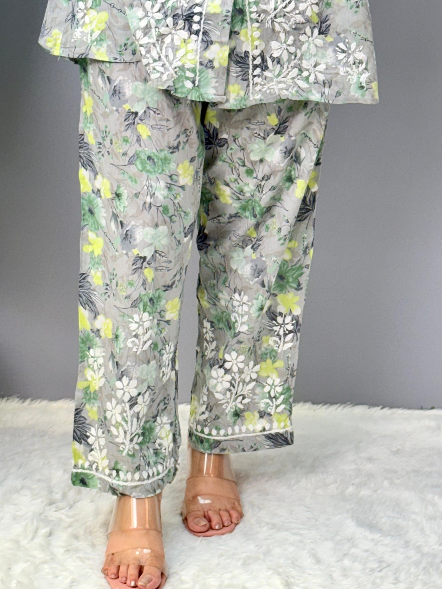 Model wearing a grey printed mulmul chikankari co-ord set with green and yellow floral design, featuring a long shirt-style kurta and matching pants.