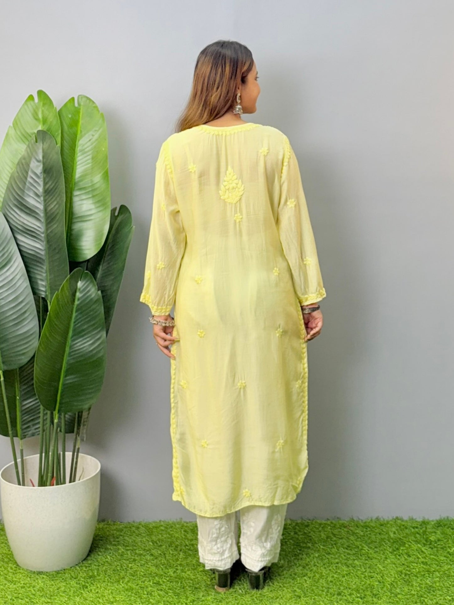Model wearing lemon yellow muslin chikankari kurta with white pants