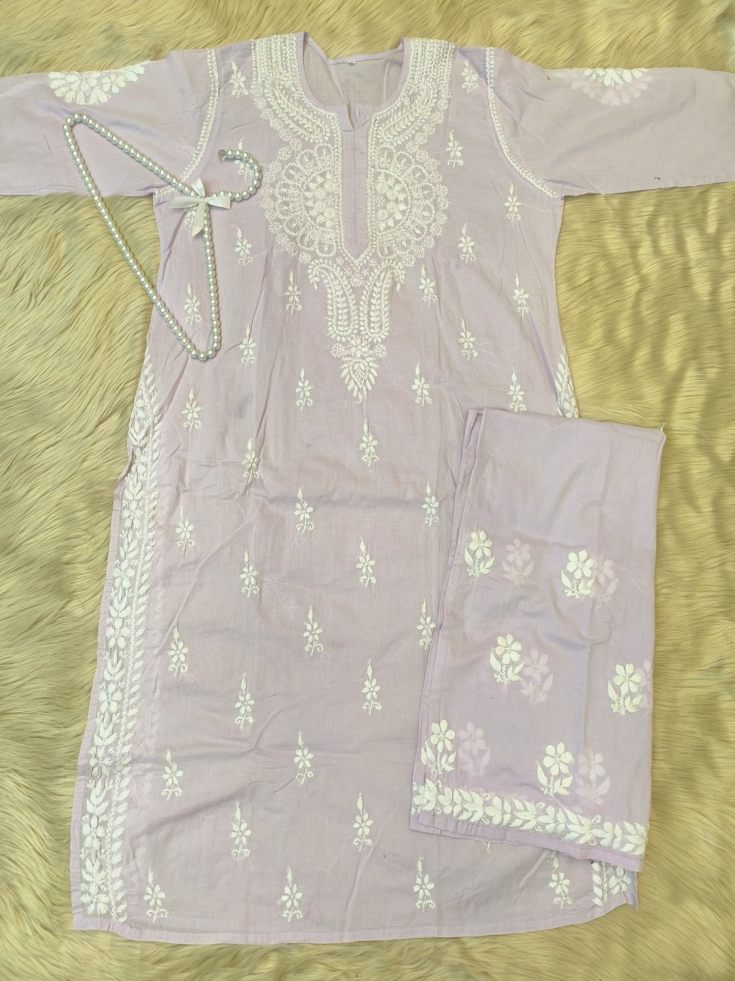 Lavender cotton chikankari kurta and palazzo set with hand embroidery, laid flat on fur background