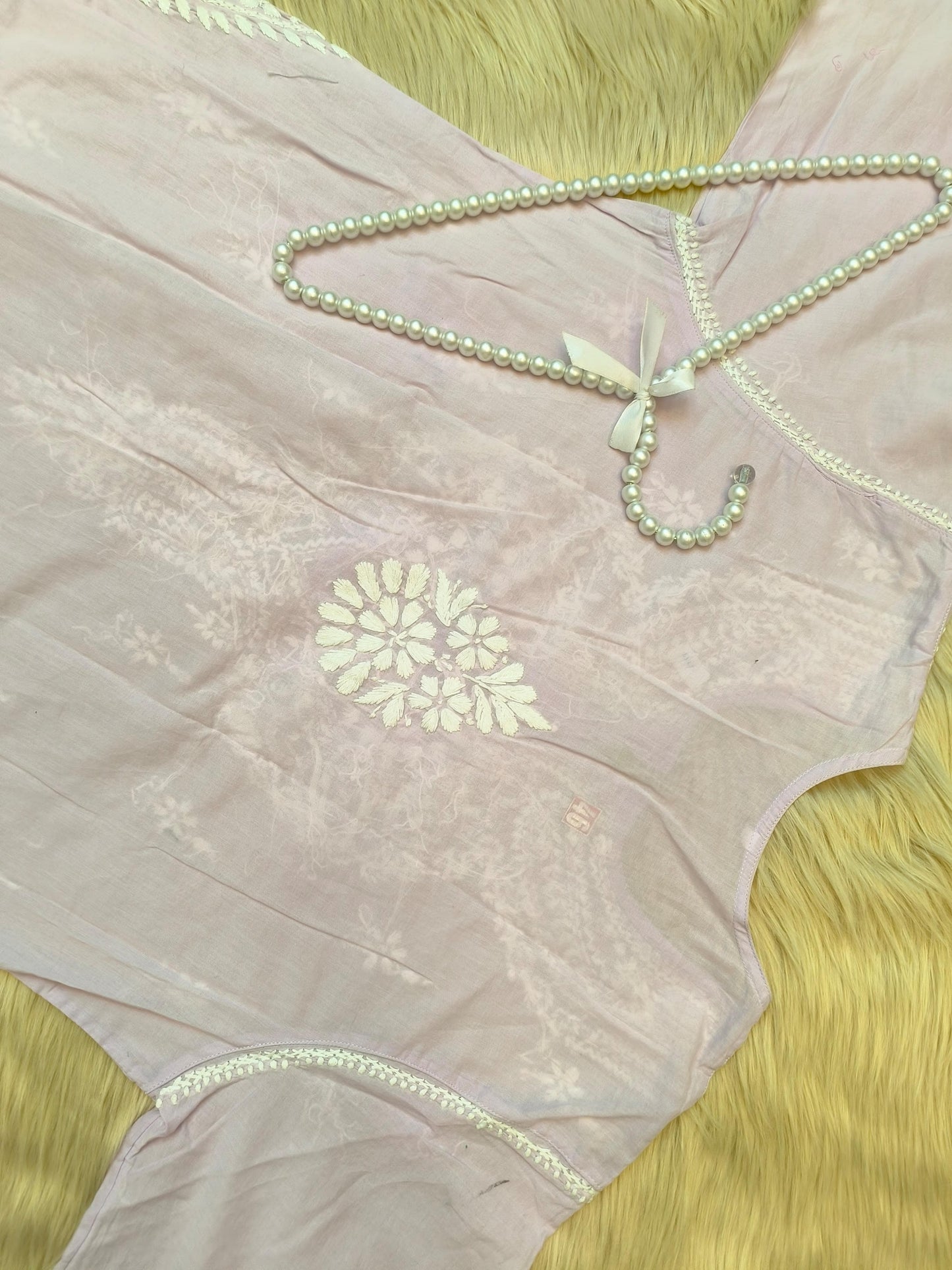 Lavender cotton chikankari kurta and palazzo set with hand embroidery, laid flat on fur background